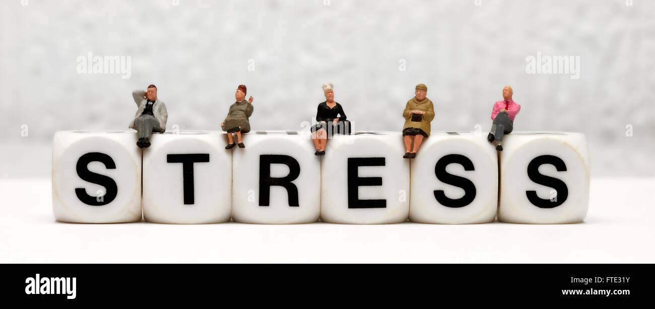 Statuine in miniatura seduta sulla parte superiore della parola lo stress Foto Stock