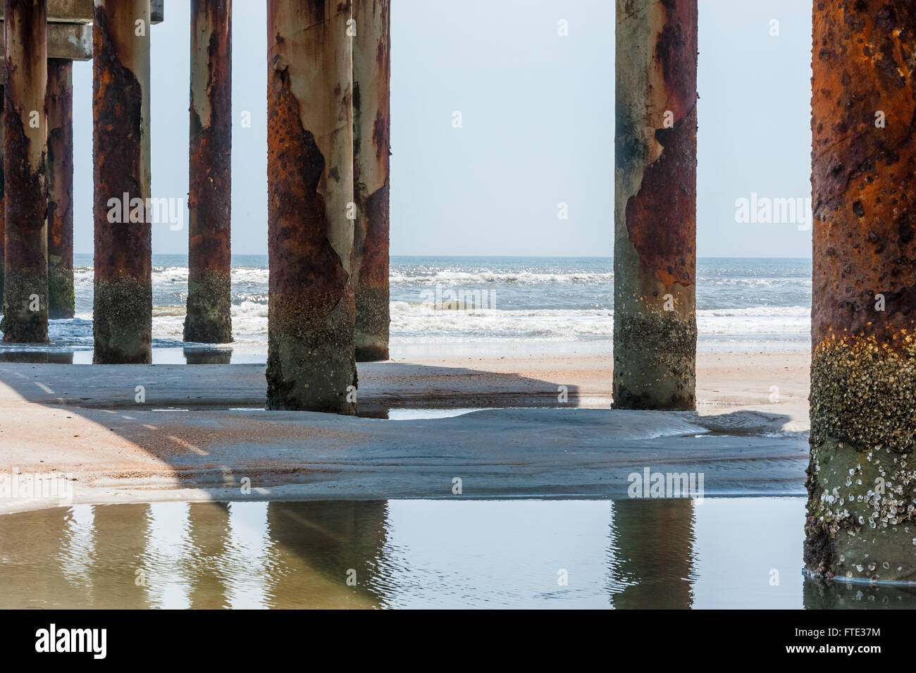 Vista oceano attraverso arrugginita palificazioni a sant'Agostino Molo di St Augustine, Florida, Stati Uniti d'America. Foto Stock