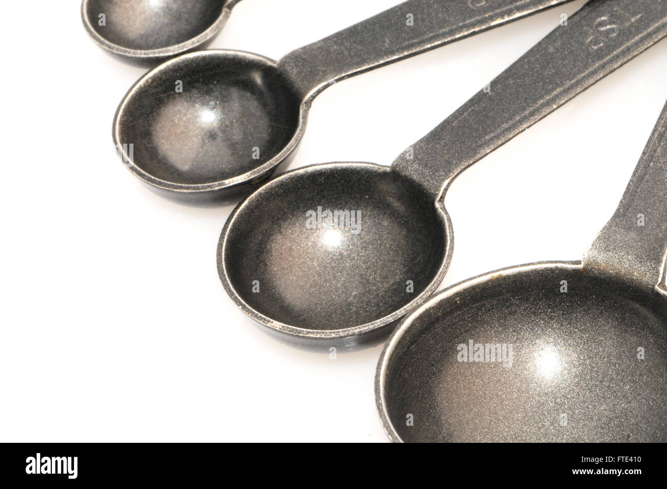 Metallo quattro cucchiai di misura isolati su sfondo bianco. Foto Stock