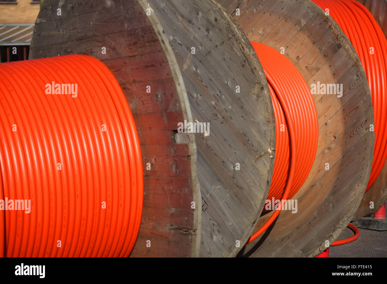 Enorme cavo arancione tamburi per le connessioni di fibre ottiche. Foto Stock
