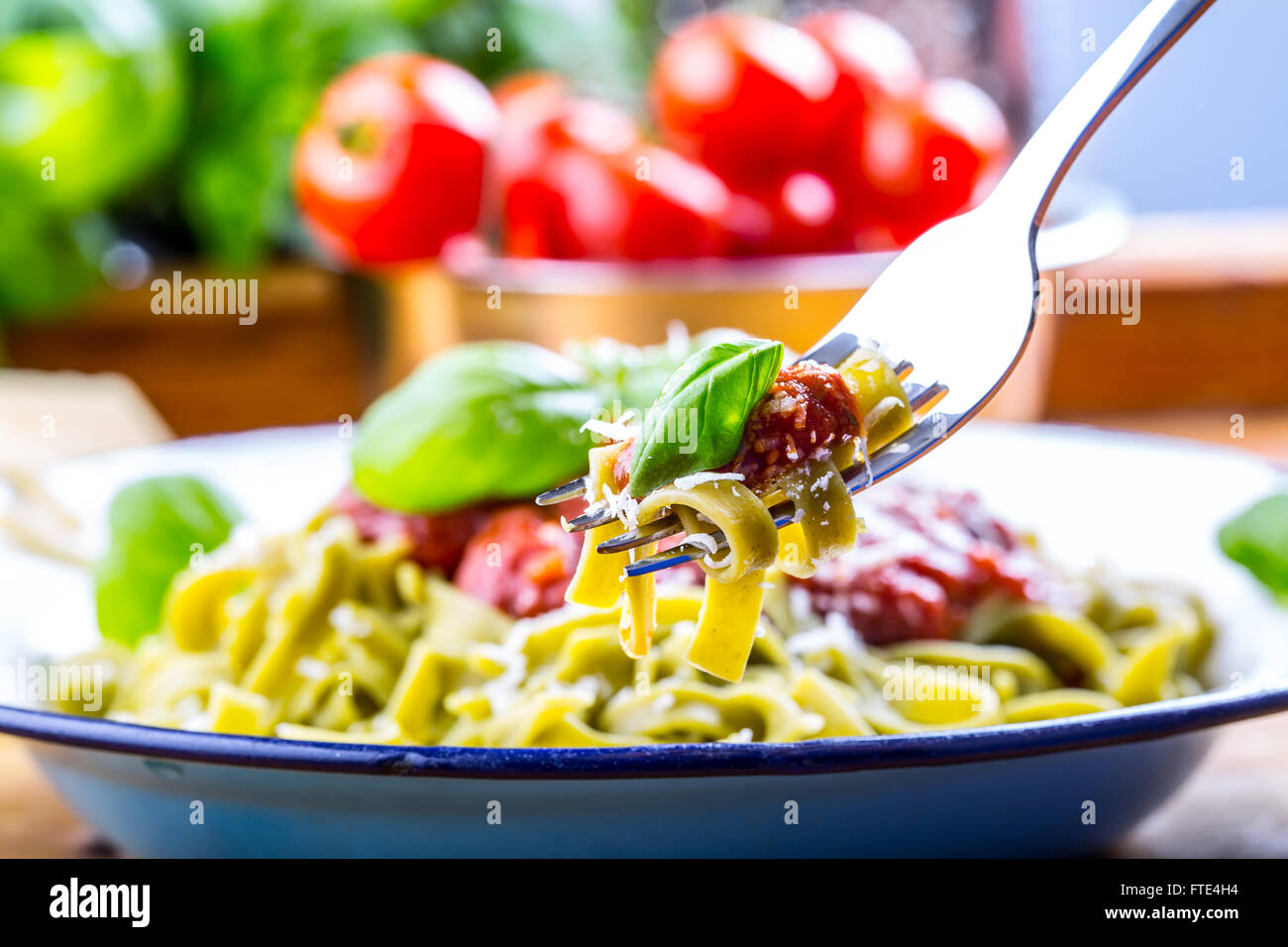 La pasta. Cucina italiana e mediterranea. Pasta Fettuccine con salsa di pomodoro foglie di basilico e aglio formaggio parmigiano. Foto Stock