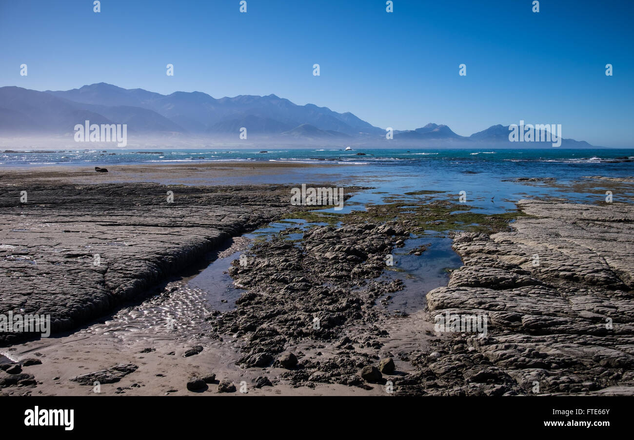 Una vista della spiaggia di Kaikoura guardando verso il Kaikoura Seaward Mountain Range Foto Stock