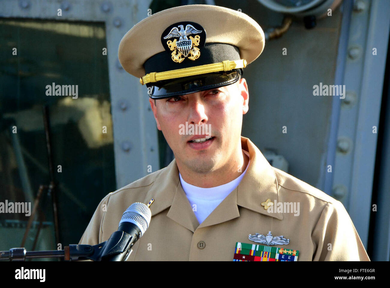 Il Chief Warrant Officer Matthew Walter di Sheridan, Oregon, parla durante la sua cerimonia di messa in servizio a bordo della USS Carney, un cacciatorpediniere missilistico guidato classe Arleigh Burke, nel novembre 2015. Foto Stock
