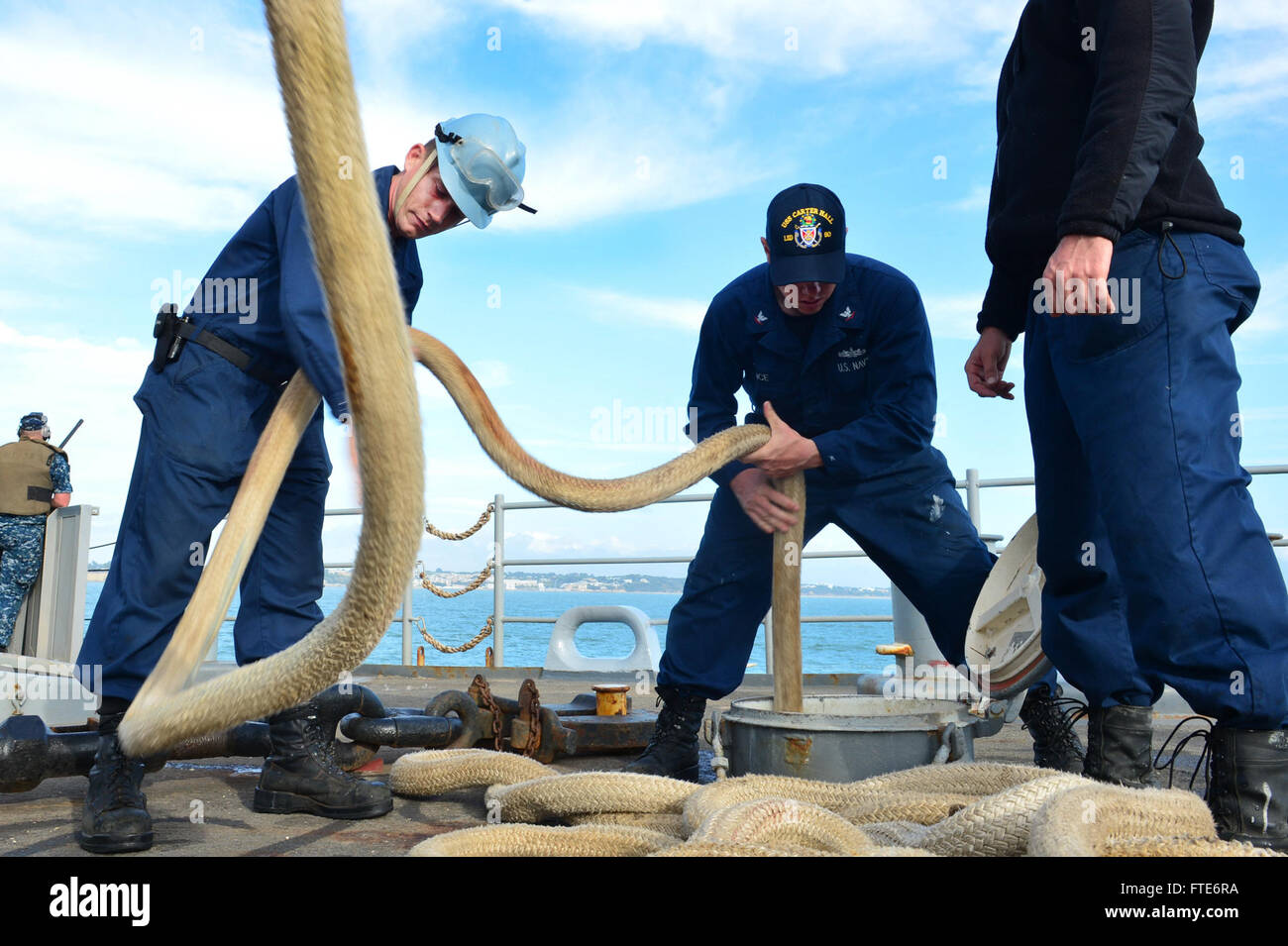 I marinai a bordo della USS Carter Hall (LSD 50) sono visti gestire la linea durante un'operazione marittima a Rota, in Spagna, come parte della loro missione di supporto alle operazioni di sicurezza e alla cooperazione per la sicurezza del teatro nell'area della 6th Fleet degli Stati Uniti. Foto Stock