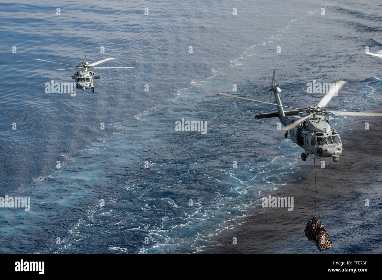 Mare Mediterraneo (ott. 29, 2013) Due MH-60S Seahawk elicotteri, assegnato al "indiani" di elicottero di mare squadrone di combattimento (HSC) 6, trasporto di rifornimenti durante un rifornimento in mare con la portaerei USS Nimitz CVN (68). Nimitz è implementato il supporto le operazioni di sicurezza marittima e di teatro la cooperazione in materia di sicurezza gli sforzi negli Stati Uniti Sesta flotta area di operazioni. (U.S. Foto di Marina di Massa Specialista comunicazione marinaio Siobhana R. McEwen/ rilasciato) Foto Stock
