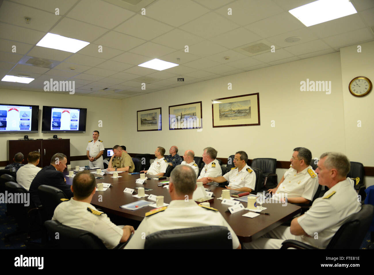 CMdR. Mustafa Tufan Uslu, membro del Barbaros Task Group della Marina turca, presenta un breve briefing post-schieramento a Napoli. Questa immagine cattura un momento significativo nella collaborazione navale internazionale e nelle operazioni militari. Foto Stock
