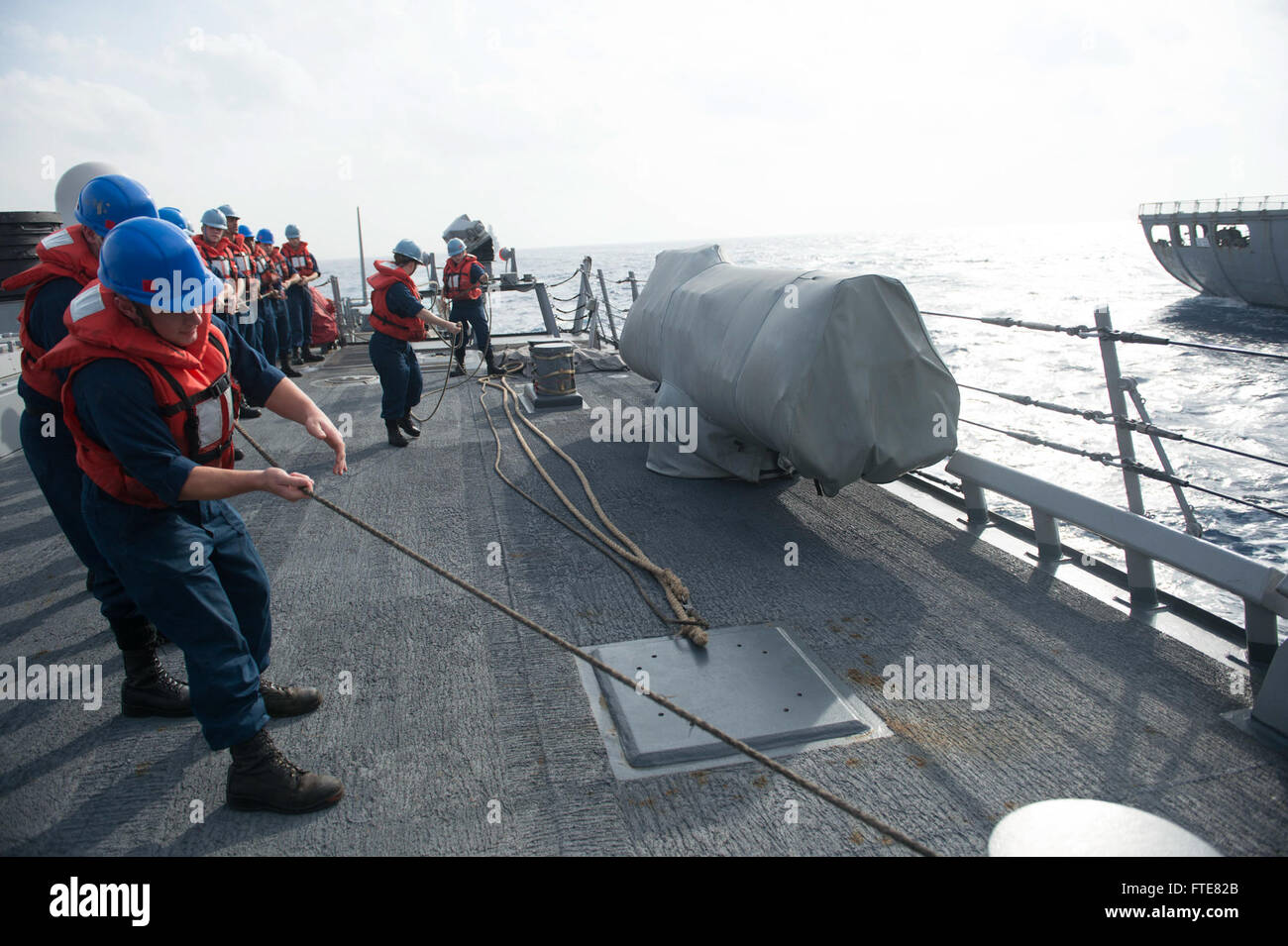 Una fotografia della Marina degli Stati Uniti scattata il 23 novembre 2013 mostra i marinai a bordo del cacciatorpediniere missilistico guidato classe Arleigh Burke USS Stout (DDG 55) durante un rifornimento in mare con la USNS Leroy Grumman (T-AO 195), a supporto delle operazioni di sicurezza marittima nell'area della 6th Fleet degli Stati Uniti. Foto Stock