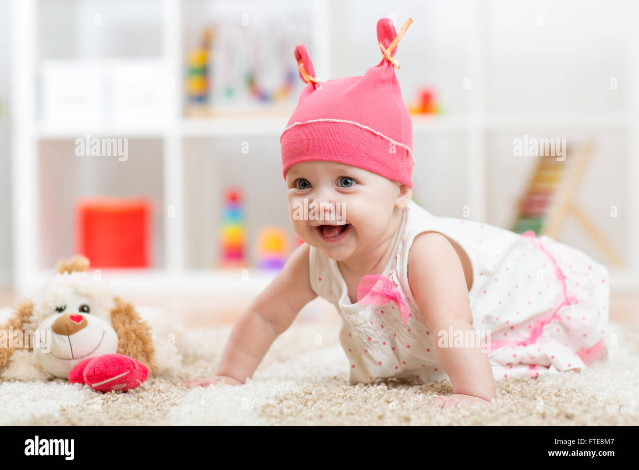 Carino con Baby toy strisciare sul pavimento Foto Stock