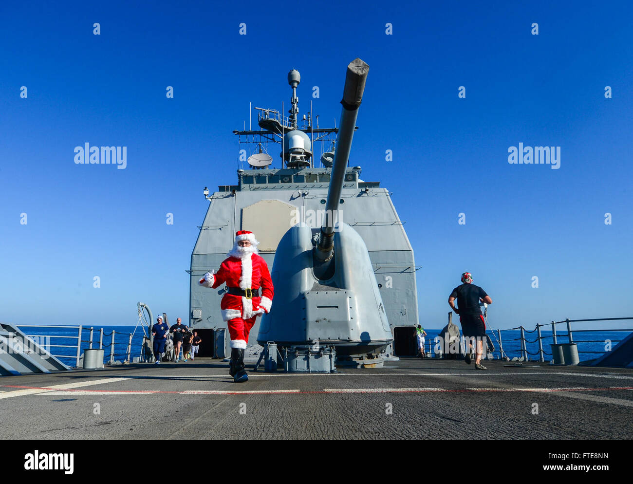 Il 22 dicembre 2013, cmdr. Darren Dugan, ufficiale esecutivo della USS *Monterey* (CG 61), vestito da Babbo Natale per fare il tifo per i marinai durante una corsa di 5K sul foc’sle della nave. La nave è stata schierata nel Mar Mediterraneo come parte delle operazioni di sicurezza marittima e degli sforzi di sicurezza regionale all'interno dell'area di operazioni della 6th Fleet degli Stati Uniti. Foto Stock