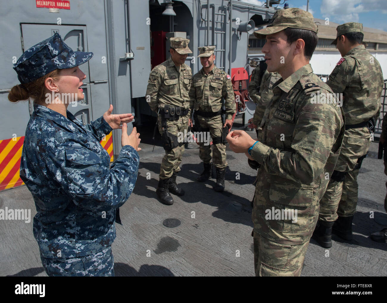 Il sottufficiale di prima classe Lindsey Jaeger discute le operazioni di interdizione marittima (MIO) con un membro turco del team MIO a bordo della fregata turca TCG Turgutreis durante l'esercitazione Phoenix Express 2015 in Tunisia. Tale esercizio mirava a migliorare la sicurezza marittima e la cooperazione regionale. Foto Stock