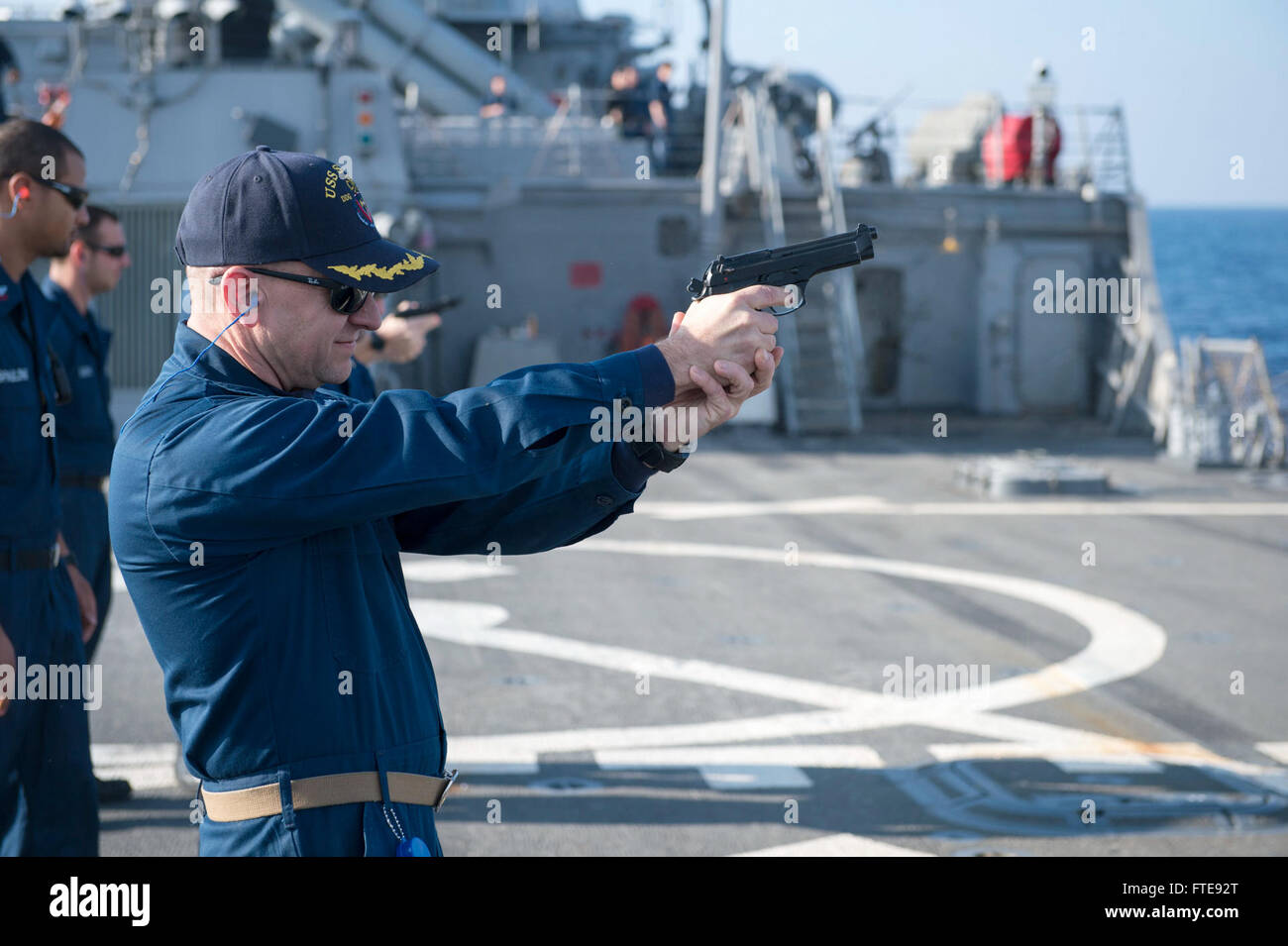 Mare Mediterraneo (GEN. 07, 2014) - Cmdr. Andrew Fitzpatrick, delegato della Arleigh Burke-class guidato-missile destroyer USS Stout (DDG 55), incendi a 9mm a pistola durante un piccoli bracci di qualificazione. Stout, homeported a Norfolk, Virginia, è su una distribuzione programmata sostenere le operazioni di sicurezza marittima e di teatro la cooperazione in materia di sicurezza gli sforzi negli Stati Uniti Sesta flotta area di operazione. (U.S. Foto di Marina di Massa lo specialista di comunicazione 2a classe Amanda R. Gray/rilasciato) Foto Stock