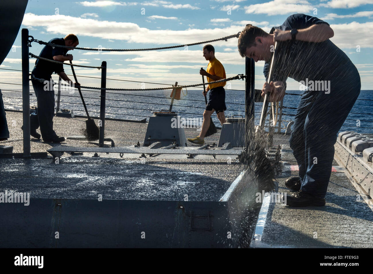 Questa immagine mostra i marinai a bordo della USS Donald Cook (DDG 75) che eseguono un lavaggio di acqua dolce sul ponte di volo del cacciatorpediniere missilistico guidato classe Arleigh Burke durante il suo transito a Rota. La USS Donald Cook fa parte di una rotazione navale nell'area delle operazioni della 6th Fleet. Foto Stock