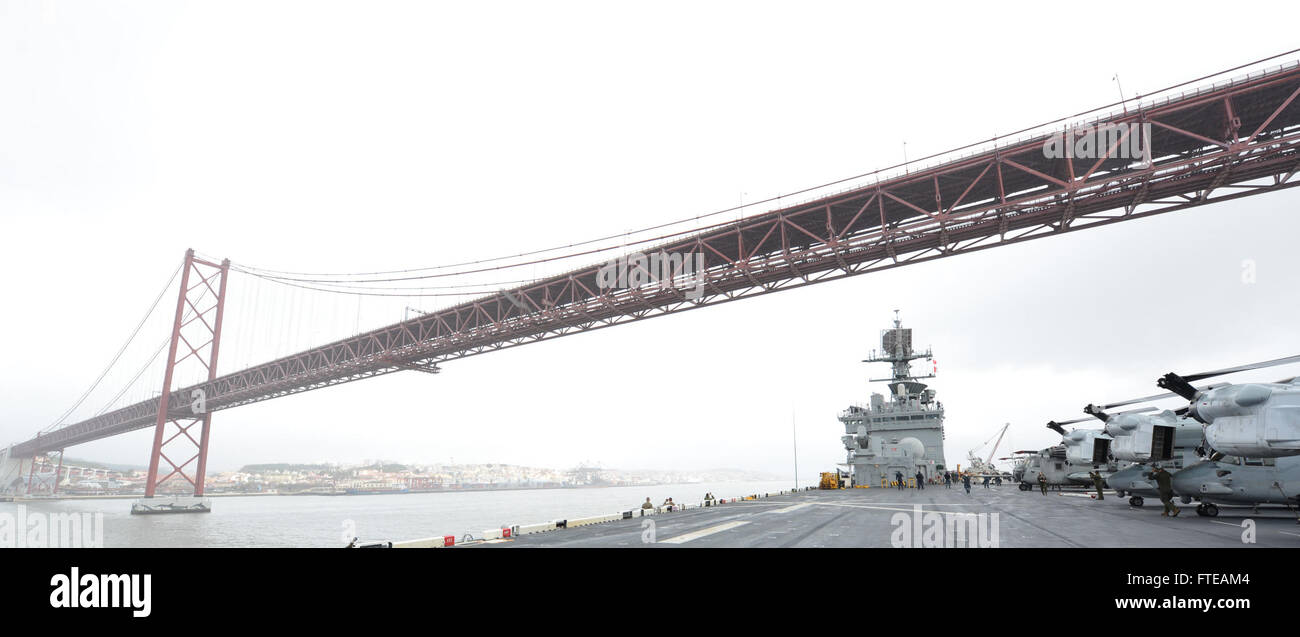 La USS Bataan (LHD 5), una nave d'assalto polivalente anfibia, passa sotto il ponte del 25 aprile mentre parte da Lisbona, Portogallo. La nave è schierata per operazioni di sicurezza marittima e risposta alle crisi nelle aree di responsabilità della 5a e 6a flotta della Marina degli Stati Uniti. Foto Stock