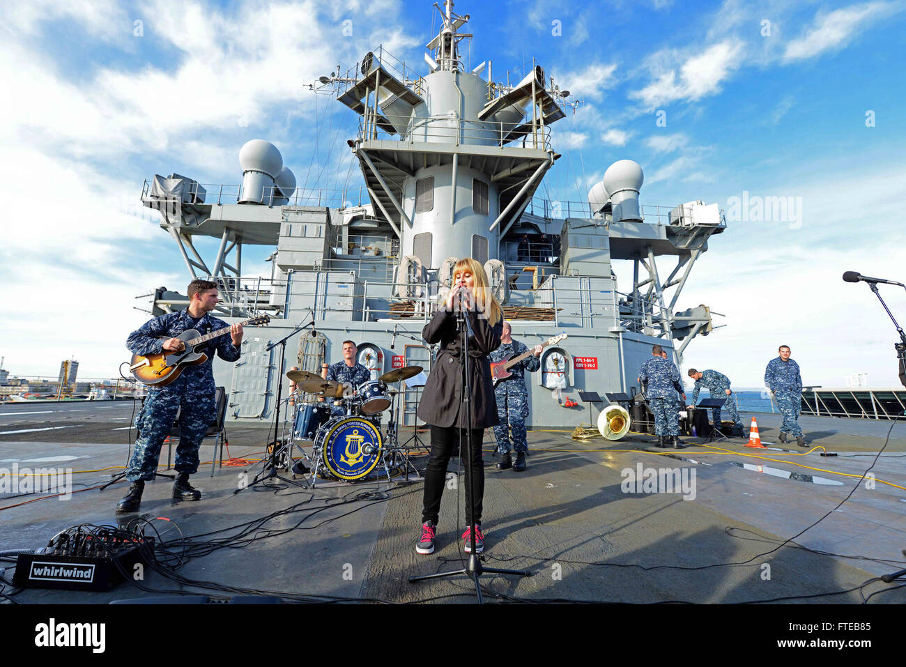 Un cantante di una scuola di musica locale a Burgas si esibisce con la U.S. 6th Fleet Command and Control Band a bordo della USS Mount Whitney (LCC 20), di stanza nel Mediterraneo come parte di una missione a sostegno degli interessi di sicurezza nazionale degli Stati Uniti in Europa. Foto Stock