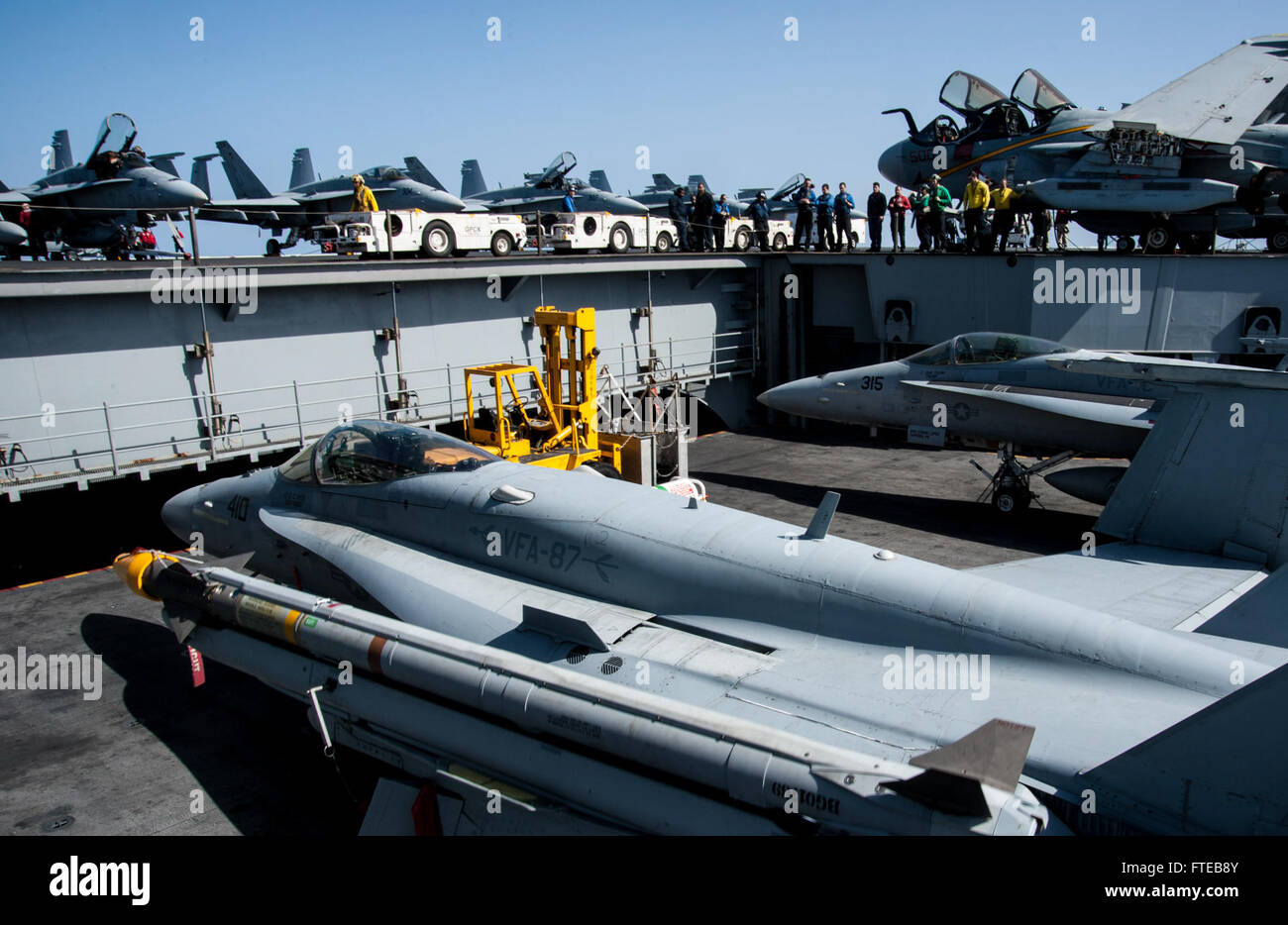 Un F/A-18 Hornet viene spostato nella cabina di pilotaggio a bordo della USS George H.W. Bush (CVN 77), a sostegno della sicurezza marittima e delle operazioni nel Mediterraneo. Questa immagine evidenzia il ruolo della Marina nella sicurezza globale e nella cooperazione internazionale. Foto Stock