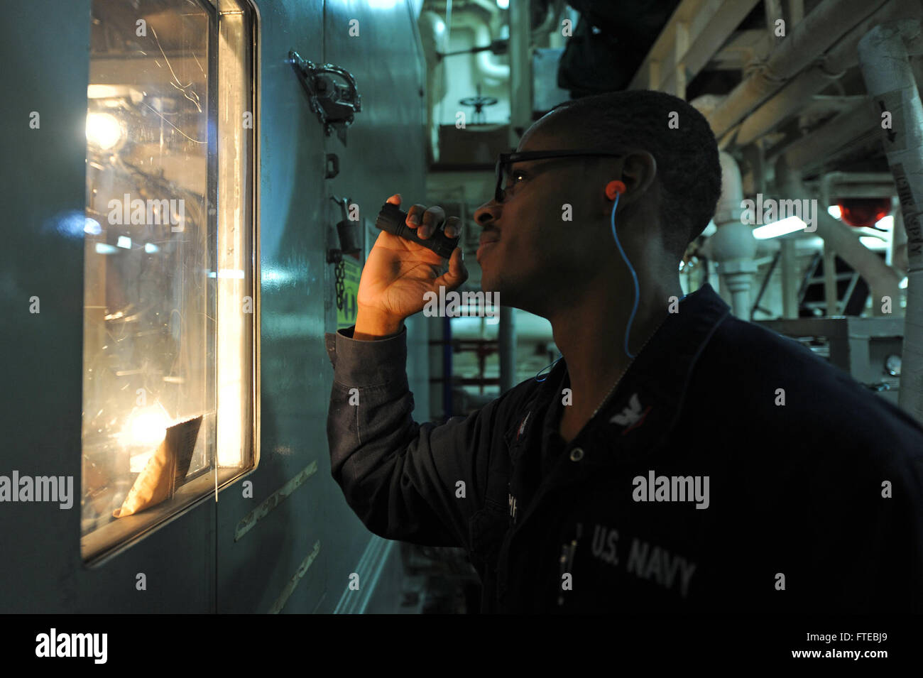 Il 10 settembre 2013, il gas turbine System Technician di terza classe Dmitri Thompson ispeziona un generatore elettrico a bordo della USS Ramage (DDG 61) durante un dispiegamento nel Mar Mediterraneo. La nave sta conducendo operazioni di sicurezza e cooperazione marittima. Foto Stock