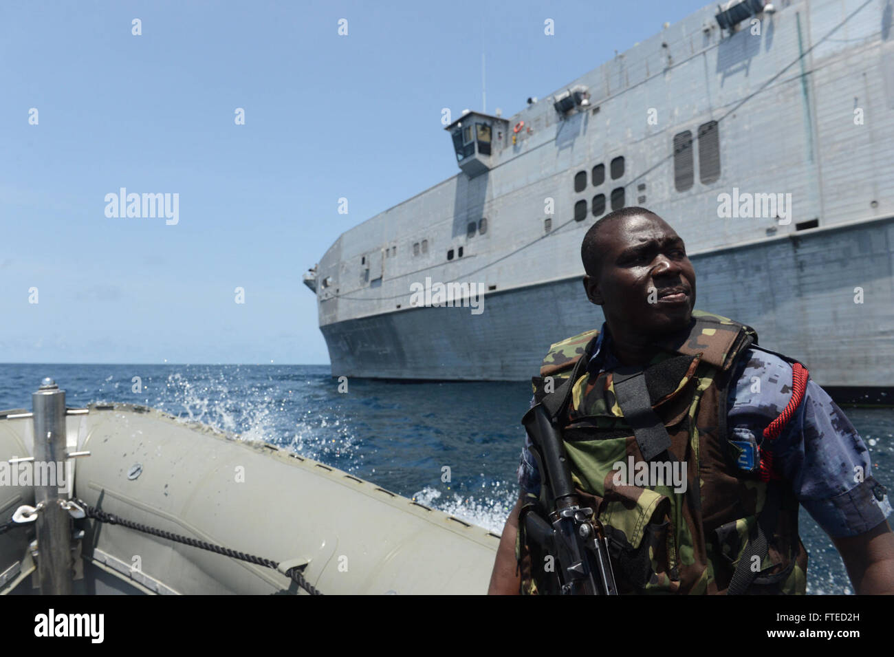 140402-N-AP176-007 del golfo di Guinea (2 aprile 2014) - Un membro del Ghana, la polizia marittimi imbarcati a bordo di giunzione, ad alta velocità a nave USNS Spearhead JHSV (1) scorre in una struttura rigida dello scafo di imbarcazione gonfiabile come parte di un STATI UNITI-Ghana combinato di diritto marittimo esecuzione operazione sotto il African Maritime Legge partenariato AMLEP (programma). AMLEP, la fase operativa di Africa Partnership Stazione (AP), riunisce U.S. Navy, U.S. Guardia costiera, e il rispettivo partner di Africa forze marittime attivamente di pattuglia che il partner delle acque territoriali ed economici della zona di esclusione con l obiettivo di intercepti Foto Stock