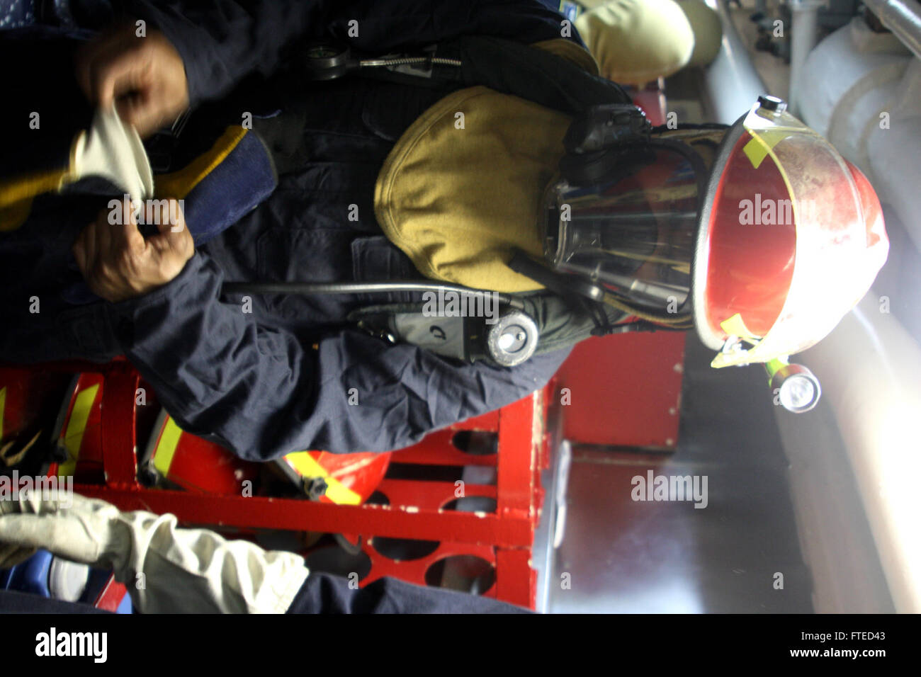 Questa foto della Marina degli Stati Uniti mostra l'investigatore antincendio Petty Officer di terza classe Ronald Hunter che si prepara per un'esercitazione a bordo della USS Leyte Gulf (CG 55), un incrociatore missilistico guidato, durante l'esercitazione Joint Warrior 14-1 al largo delle coste scozzesi. Foto Stock