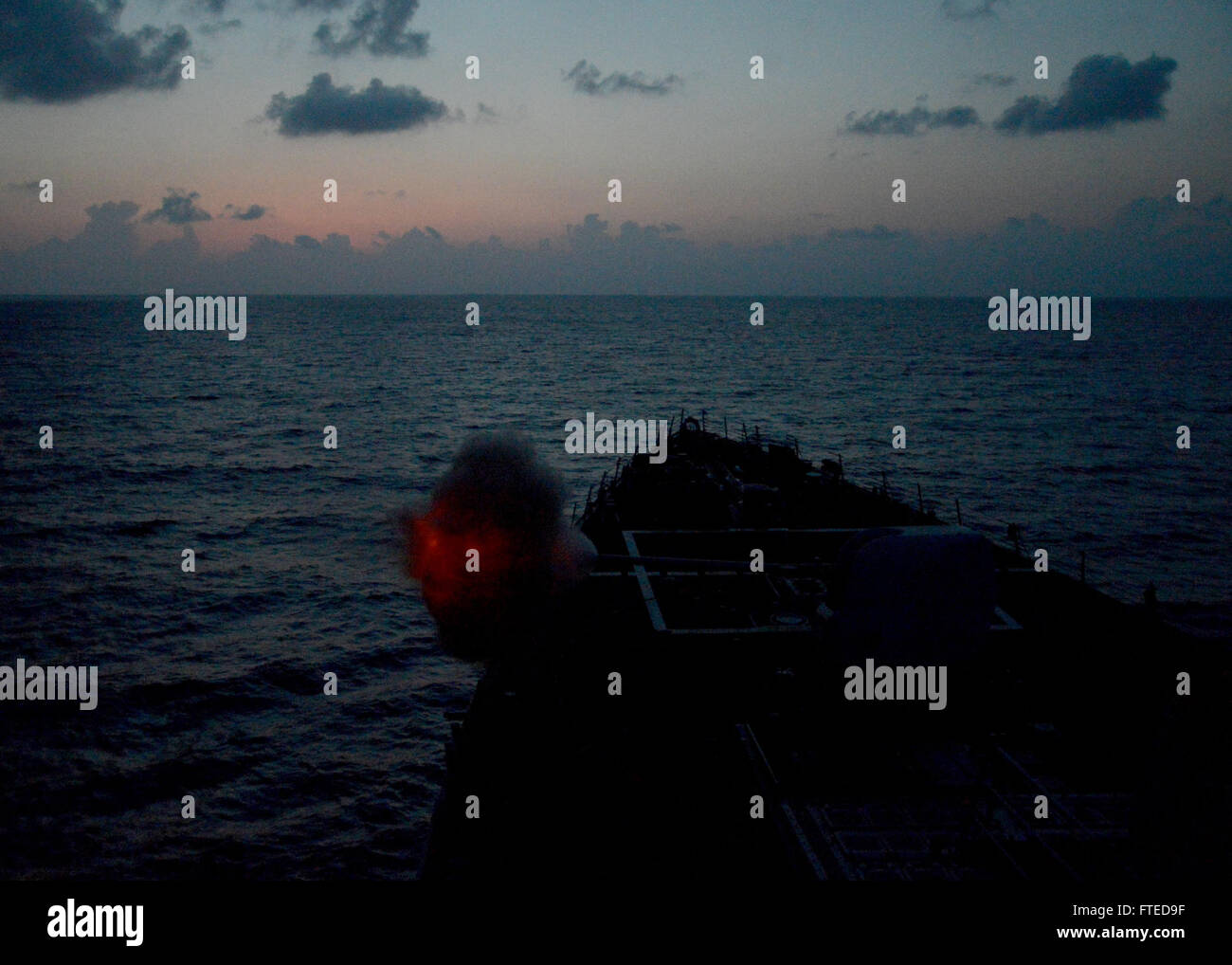 Lo USS *Ramage* (DDG 61), un cacciatorpediniere missilistico guidato, conduce un'esercitazione di fuoco vivo con il suo cannone da 5 pollici durante una missione di addestramento nel Mar Mediterraneo. Questo esercizio mira a migliorare la preparazione al combattimento e l’efficienza operativa della nave. Foto Stock