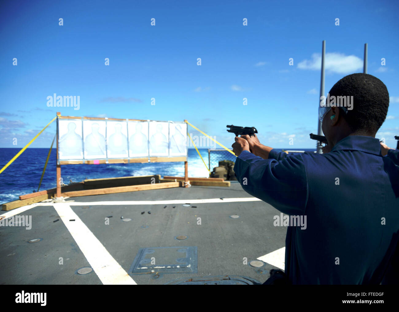 140415-N-CH661-510: Mare Mediterraneo (15 aprile 2014) - Nave veteran di seconda classe Jeffrey Mosley, assegnati alle visite-missile destroyer USS Ramage (DDG 61), incendi di un 9 mm pistola durante piccole armi qualifiche sul ponte di volo. Ramage homeported a Norfolk, Virginia, è su una distribuzione programmata sostenere le operazioni di sicurezza marittima e di teatro la cooperazione in materia di sicurezza gli sforzi negli Stati Uniti Sesta flotta area di operazioni. (U.S. Foto di Marina di Massa lo specialista di comunicazione 2a classe Jared re/RILASCIATO) Unisciti alla conversazione su Twitter ( https://twitter.com/naveur navaf ) follow us on Facebook Foto Stock