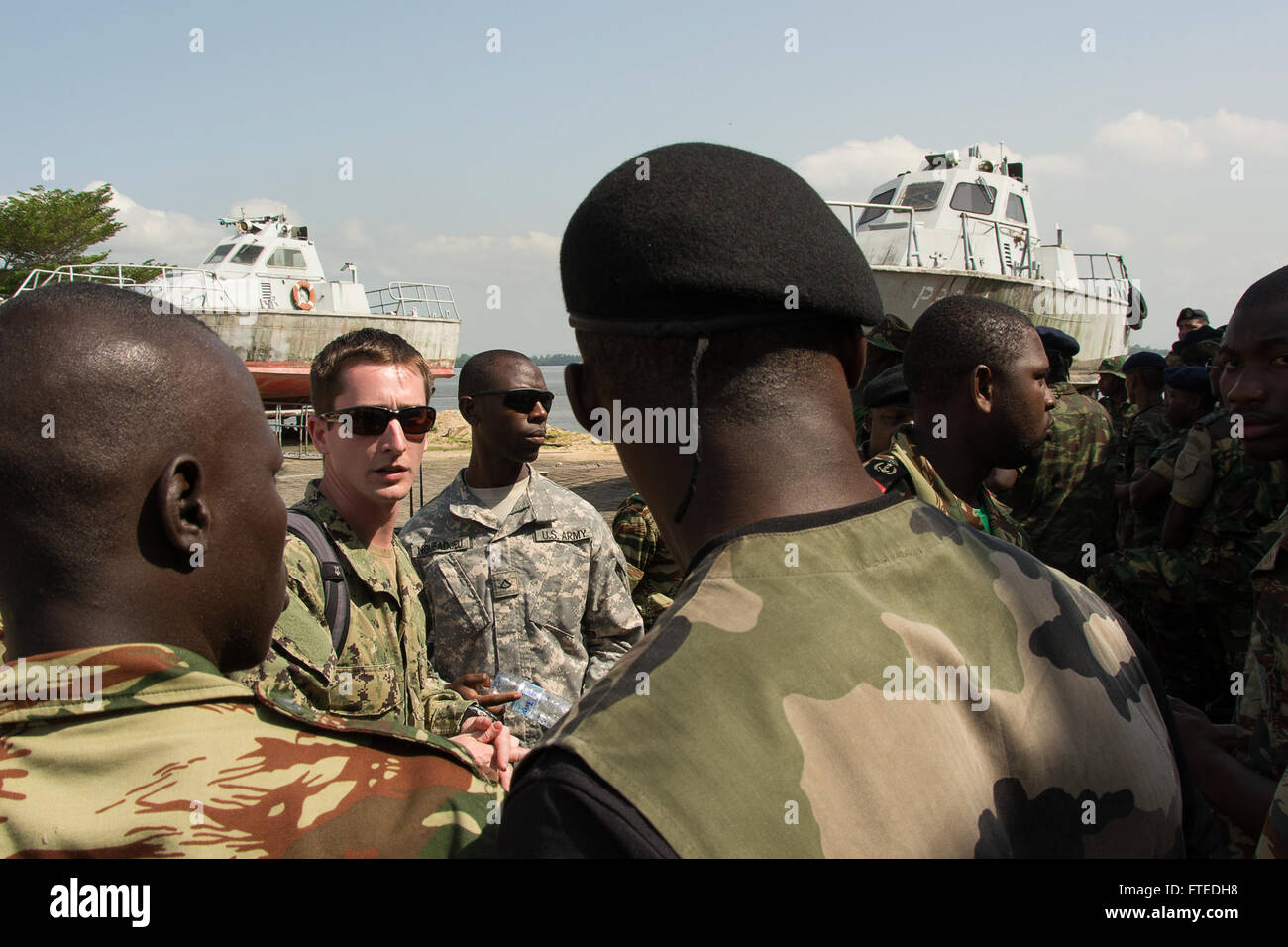 Il sottufficiale di seconda classe Brian Ott interagisce con il personale militare africano a Douala, in Camerun, come parte dell'esercitazione Obangame Express 2014. L'esercizio mira a rafforzare le competenze di cooperazione e interdizione tra le forze marittime nell'Africa occidentale e centrale per migliorare la sicurezza marittima regionale. (Foto della Marina degli Stati Uniti di Matt Wright, specialista di comunicazione di massa di terza classe) Foto Stock