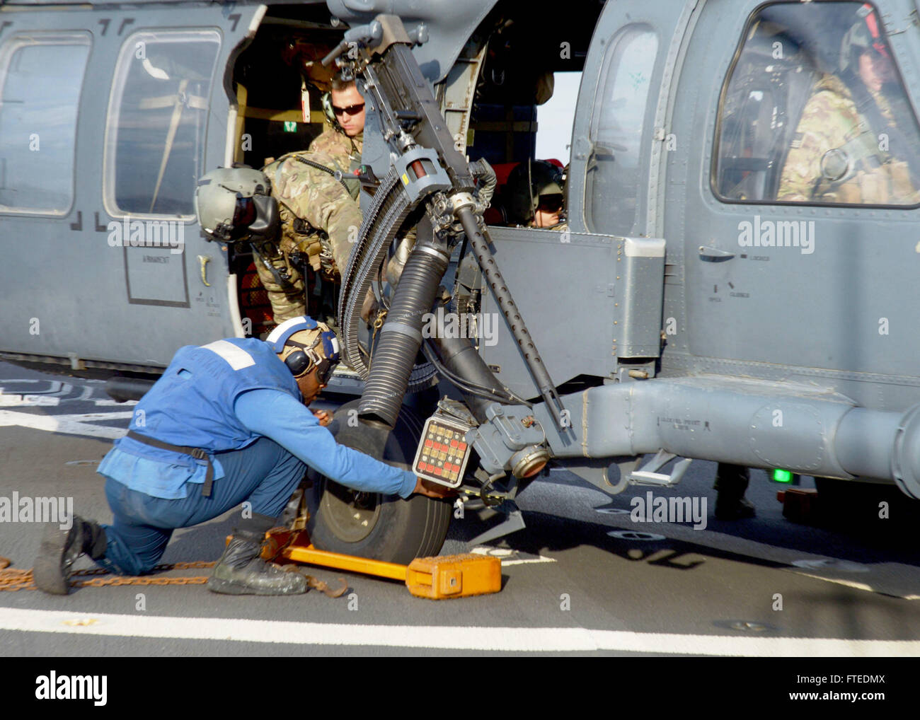 Il 18 aprile 2014, il Mate Seaman Jeremiah Bennett di Boatswain assicura catene di ancoraggio su un elicottero HH-60G Pave Hawk sulla USS Ramage (DDG 61), un cacciatorpediniere missilistico guidato, durante uno schieramento a sostegno della sicurezza marittima nel Mar Mediterraneo. Foto Stock