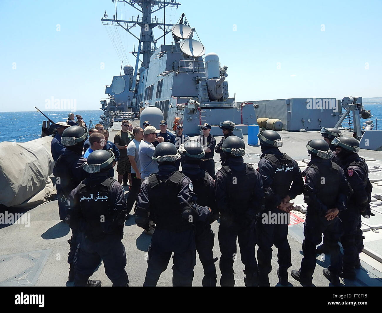 140614-N-GS541-347: Mare Mediterraneo (14 giugno 2014) - visita la scheda, la ricerca e il sequestro di squadre da visite-missile destroyer USS James E. Williams (DDG 95) e la marina militare tunisino Patrol Craft La Galite discutere le tecniche di imbarco sul missile aft deck di James E. WILLIAMS. Gli esercizi prendendo posto erano parte di uno sforzo per accrescere le competenze di entrambe le squadre e a rafforzare la sicurezza marittima nella regione del Mediterraneo. (U.S. Navy foto di alfiere Michael Scarborough/rilasciato) Foto Stock