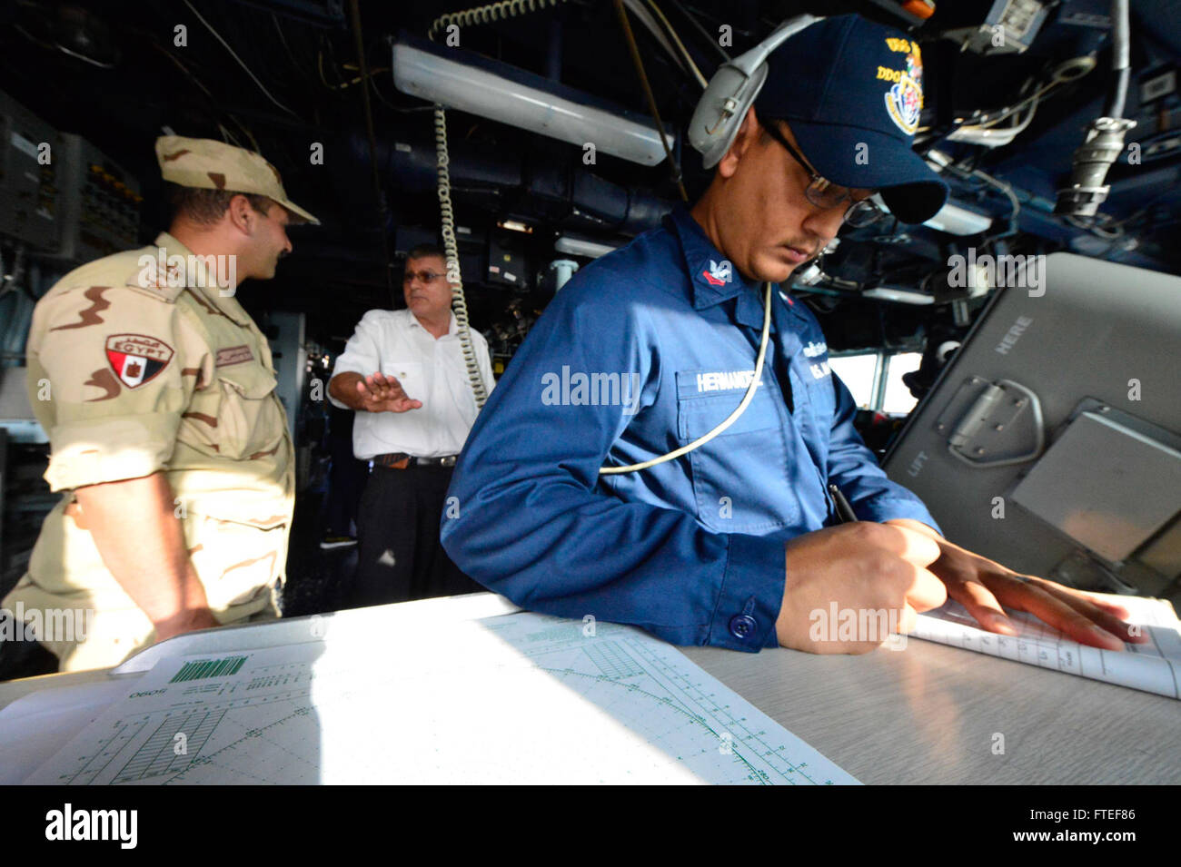 La fotografia del 30 giugno 2014 mostra il Quarter Master di seconda Classe Pedro Hernandez a bordo della USS Nitze durante il suo transito attraverso il Canale di Suez. L'immagine cattura la cooperazione militare con i funzionari egiziani e le operazioni navali statunitensi in Africa. Foto Stock