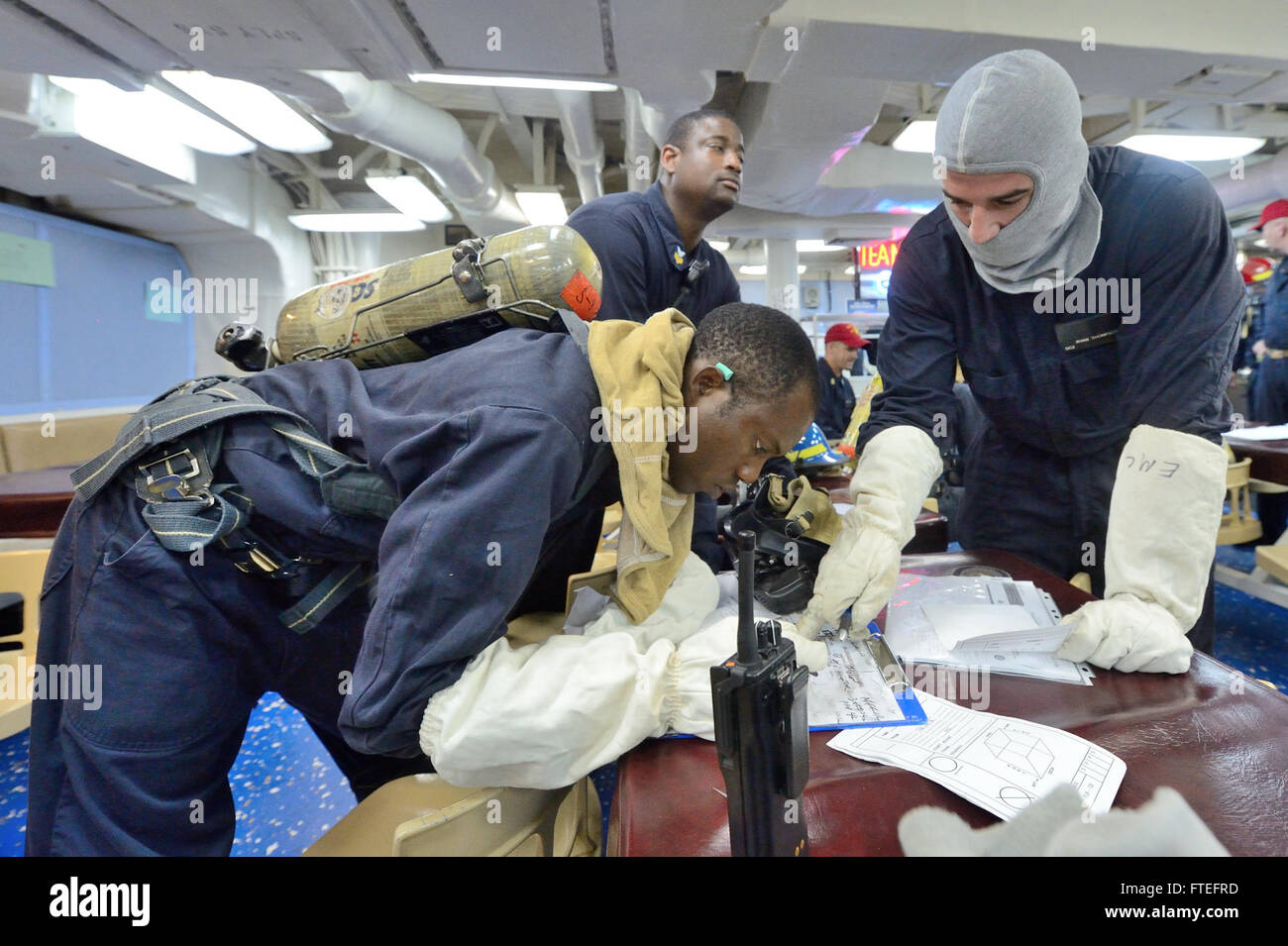 Il 13 agosto 2014, Damage Controlman 3rd Class Bamidele Kuteyi e Damage Controlman 2nd Class Ryan Thompson condussero un'esercitazione generale a bordo della USS Ross (DDG 71). Questa esercitazione, parte di un esercizio di addestramento della Marina degli Stati Uniti, si è svolta nel Mar Mediterraneo per migliorare la preparazione operativa. Foto Stock