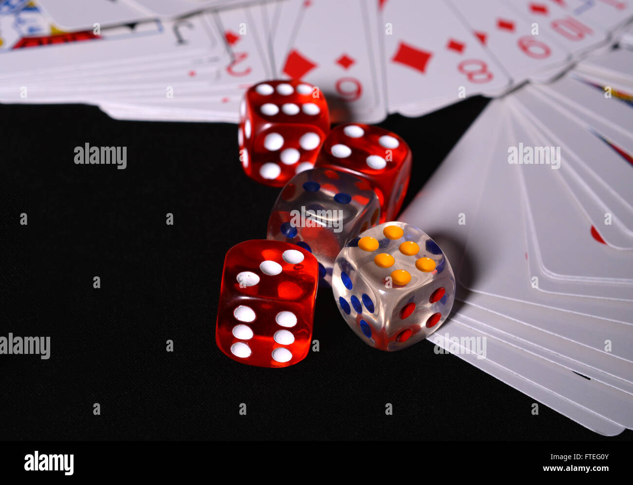 Dadi rossi con carte da gioco su sfondo nero concetto. Foto Stock