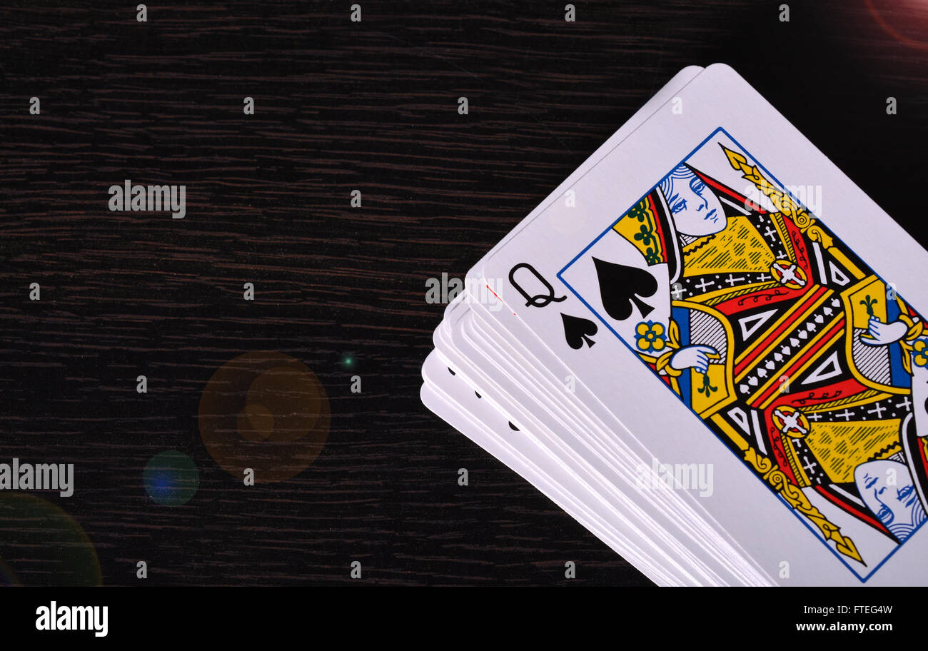 Mazzo di carte da gioco con la regina scheda su uno sfondo di legno. Foto Stock
