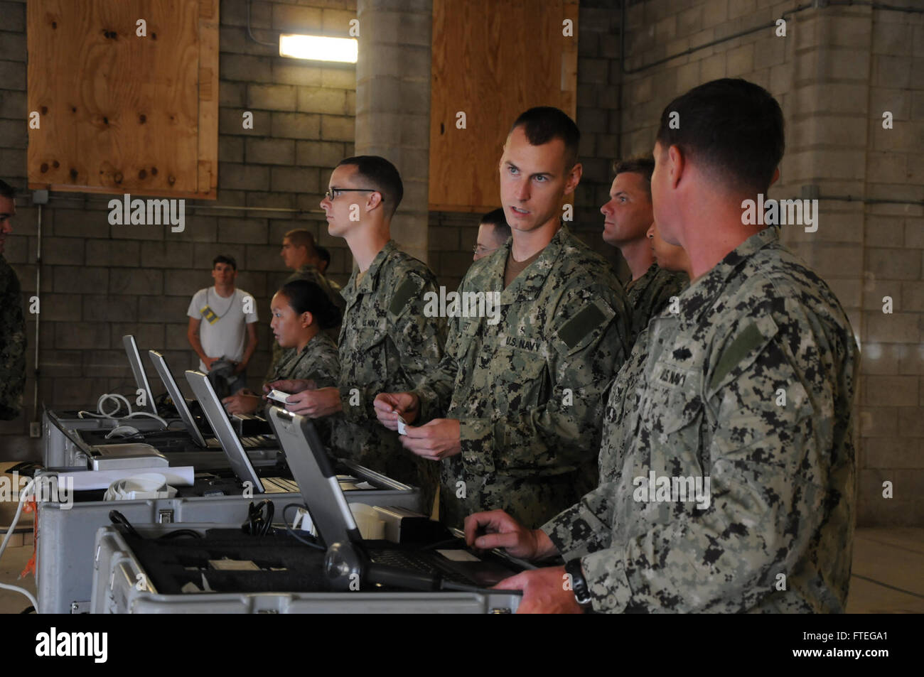 I marinai del comandante della Naval Expeditionary Task Force Europe and Africa (CTF 68) conducono controlli di identificazione degli evacuati durante un'esercitazione congiunta con i Marine della Fleet Anti-Terrorism Security Team (FAST) presso la stazione navale di Rota, Spagna. L'esercitazione è stata progettata per addestrare il personale per le operazioni di evacuazione di emergenza nelle aree del comando europeo degli Stati Uniti e dell'Africa. Foto Stock