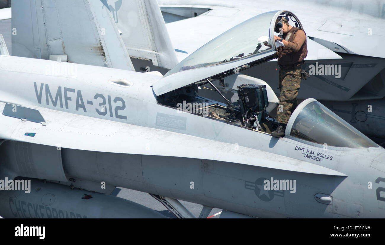 Ricardo Robles del Marine Fighter Attack Squadron 312 'scacchiere' prepara un F/A-18C Hornet per le operazioni di volo a bordo della USS Harry S. Truman (CVN 75) durante uno schieramento a sostegno degli sforzi di sicurezza nazionale degli Stati Uniti. Questa immagine mostra il lavoro vitale dell'equipaggio di terra nel mantenere la preparazione degli aeromobili. Foto Stock