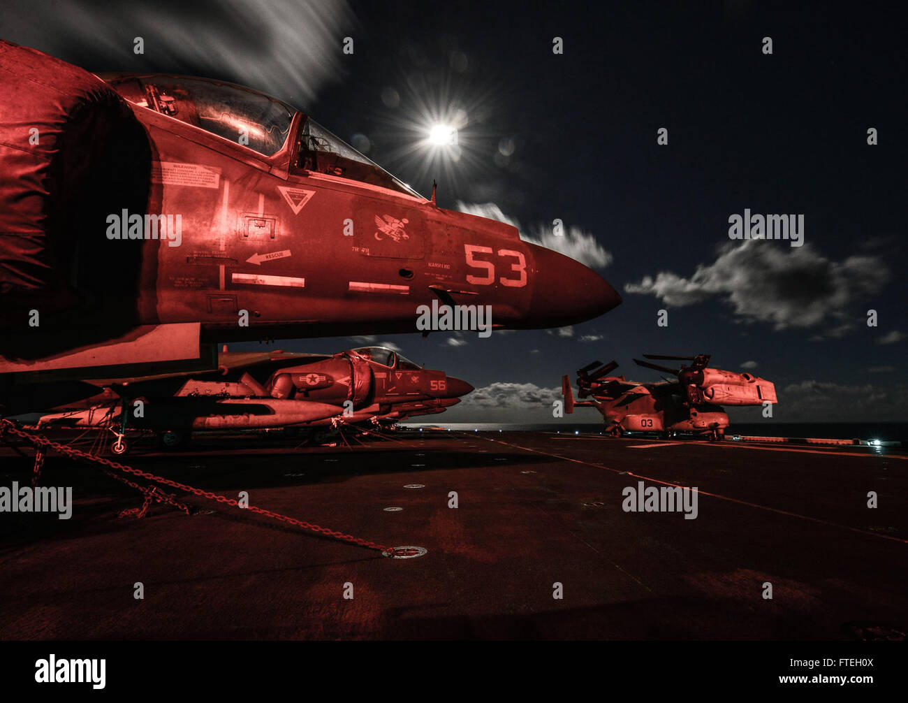 Mare Mediterraneo (ott. 8, 2014) -- AV-8B Harriers e una MV-22 Osprey sedersi sul ponte di volo di notte a bordo dell'assalto anfibio nave USS Bataan (LHD 5). Il Bataan anfibio gruppo pronto è su una distribuzione programmata sostenere le operazioni di sicurezza marittima, fornendo crisi la capacità di risposta e il teatro di sicurezza gli sforzi di cooperazione negli Stati Uniti Sesta flotta area di operazioni. Foto Stock