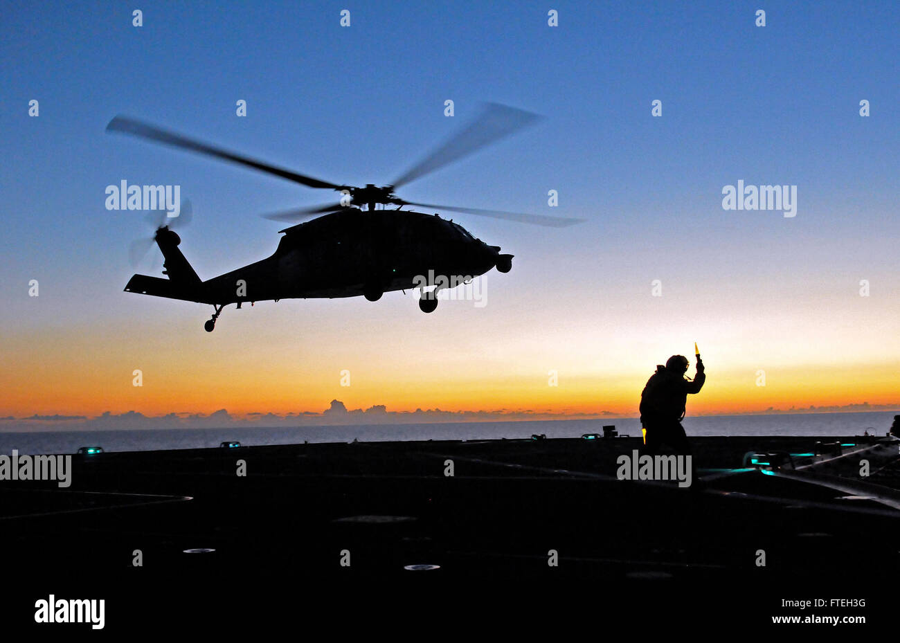 Il mar Ionio (ott. 09, 2014) un servizio civile mariner dirige un MH-60S Sea Hawk elicottero assegnato all'Ghostriders di elicottero di mare squadrone di combattimento (HSC) 28 durante la fase di decollo da parte degli Stati Uniti 6 comando della flotta e la nave di controllo USS Mount Whitney (LCC 20). Il Monte Whitney, homeported in Gaeta, Italia, opera con un combinato di equipaggio di marinai e militari di comando Sealift servizio civile naviganti. ( U.S. Foto di Marina di Massa lo specialista di comunicazione 2a classe Mike Wright/ rilasciato) Foto Stock