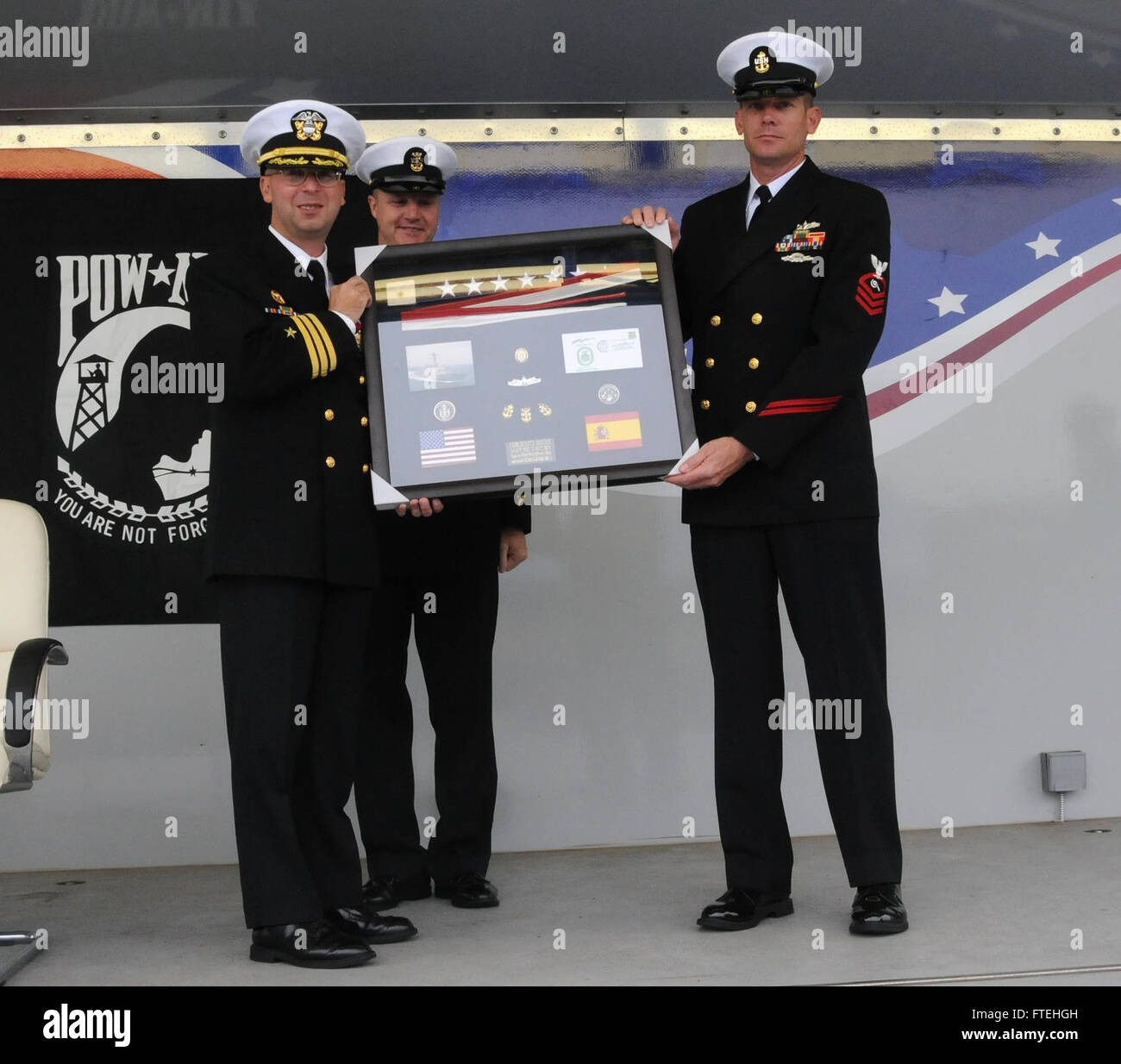 La stazione navale di Rota, Spagna (17 ottobre 2014) - Cmdr. Scott Jones, sinistra, riceve un dono dall'equipaggio della USS Donald Cook (DDG 75) durante un cambio del comando cerimonia, Ott. 17. Donald Cook è il primo di quattro Arleigh Burke-cacciatorpediniere della classe per essere distribuita a Rota, Spagna, come parte del Presidente della Comunità graduale approccio adattativo (EPAA) al missile balistico di difesa in Europa. Foto Stock