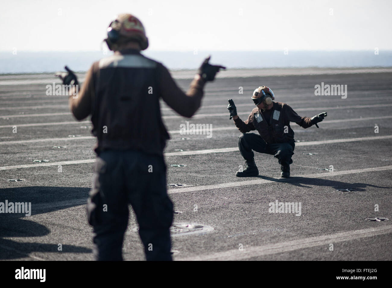 Mare Mediterraneo (ott. 31, 2014) Aviazione meccanico strutturale Airman Londra Olan, da Toledo, Ohio, sinistra e Airman Ian Torres, da Sacramento, California, stand come osservatori di sicurezza come un F/A-18C Hornet, attaccato al "Golden guerrieri" di Strike Fighter Squadron (VFA) 87, conduce una bassa potenza accendere il ponte di volo della portaerei USS George H.W. Bussola (CVN 77). George H.W. Bush, homeported a Norfolk, Virginia, sta conducendo operazioni navali negli Stati Uniti Sesta flotta area di operazioni a sostegno degli Stati Uniti per gli interessi di sicurezza nazionali in Europa. Foto Stock