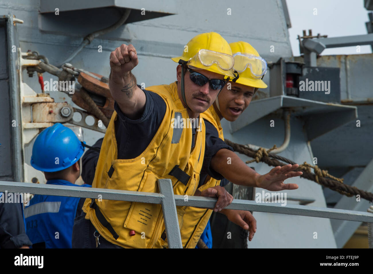 Mare Mediterraneo (nov. 16, 2014) - di Boatswain Mate 2a classe Alan Farthing, sinistra, da Grove City, Ohio, e di Boatswain Mate 3° di classe Dontrell Dorsett, da Fort Worth, Texas, dare istruzioni ai gestori di linea a bordo della USS Cole (DDG 67) durante un rifornimento in mare con la USNS Leroy Grumman (TAO 95). Cole, un Arleigh Burke-class guidato-missile destroyer homeported in Norfolk, sta conducendo operazioni navali negli Stati Uniti Sesta flotta area di operazioni a sostegno degli Stati Uniti per gli interessi di sicurezza nazionali in Europa. Foto Stock