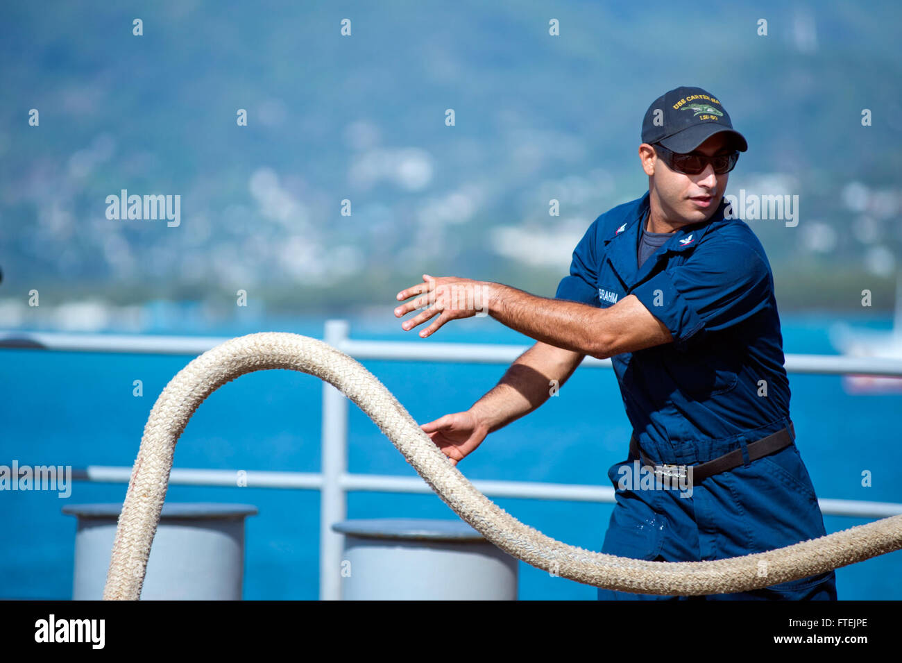 PORT victoria Seychelles (Agosto 25, 2013) di Boatswain Mate 3° di classe Christopher Ibrahim gestisce la linea a bordo del dock anfibio sbarco nave USS Carter Hall (LSD 50) come la nave tira al porto di Victoria per una porta programmata visita. Carter Hall è una parte di anfibio Kearsarge pronto il gruppo e con la ventiseiesima imbarcato MEU, è distribuito come supporto di le operazioni di sicurezza marittima e di teatro la cooperazione in materia di sicurezza gli sforzi negli Stati Uniti La quinta e la sesta flotta area di responsabilità. Foto Stock