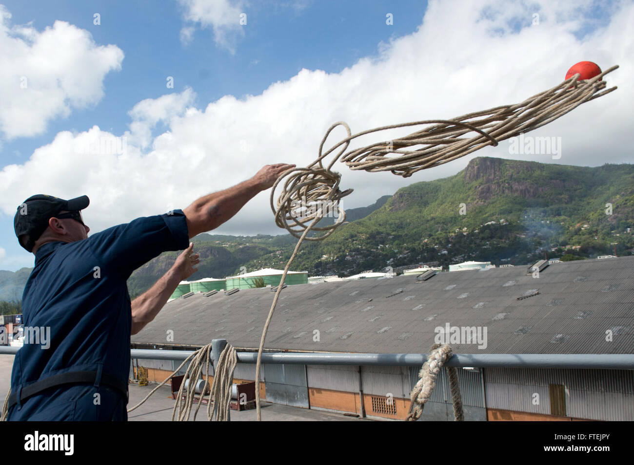 Il Boatswain's Mate di seconda classe Andrew Minella a bordo della USS Carter Hall (LSD 50) è in linea mentre la nave si avvicina a Port Victoria. La USS Carter Hall, parte del Kearsarge Amphibious Ready Group, è schierata per le operazioni di sicurezza marittima e la sicurezza del teatro nelle aree della 5a e 6a flotta degli Stati Uniti. Foto Stock
