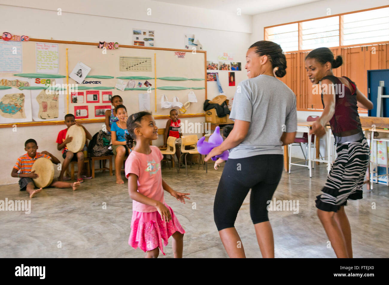 Il 26 agosto 2013, il capo (Select) Yeoman Chere Wilson, assegnato alla USS Carter Hall (LSD 50), si unisce alla gente del posto nella danza durante un progetto di servizio alla Beau Vallon School di Port Victoria, Seychelles, come parte dell'impegno della Marina degli Stati Uniti con le comunità locali. Foto Stock
