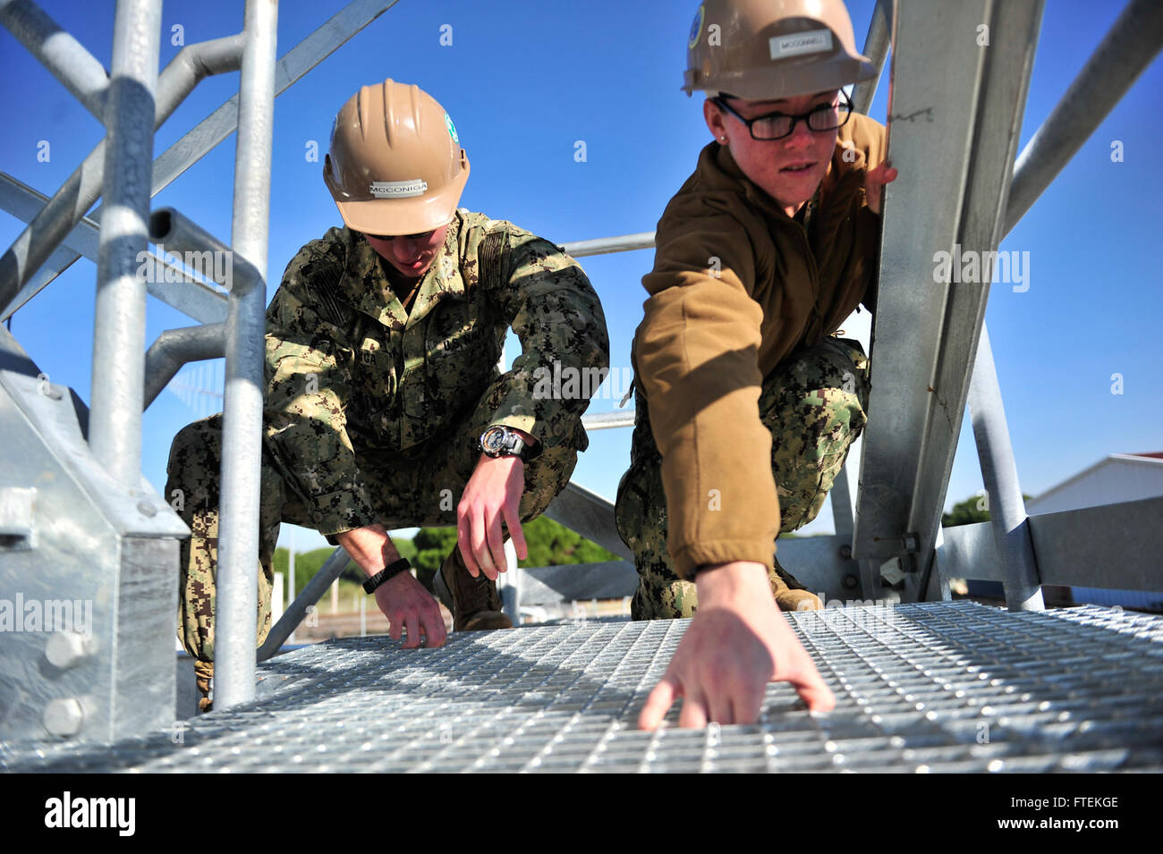 Questa immagine tratta dalla stazione navale di Rota, Spagna, scattata il 28 gennaio 2015, mostra il costruttore di acciaierie Kyle McConiga e il costruttore Samantha McConnel che ispezionano le griglie di passaggio di un complesso di apparecchiature elettroniche. Il complesso, una volta completato, testerà le attrezzature di bordo per le operazioni navali. Foto Stock