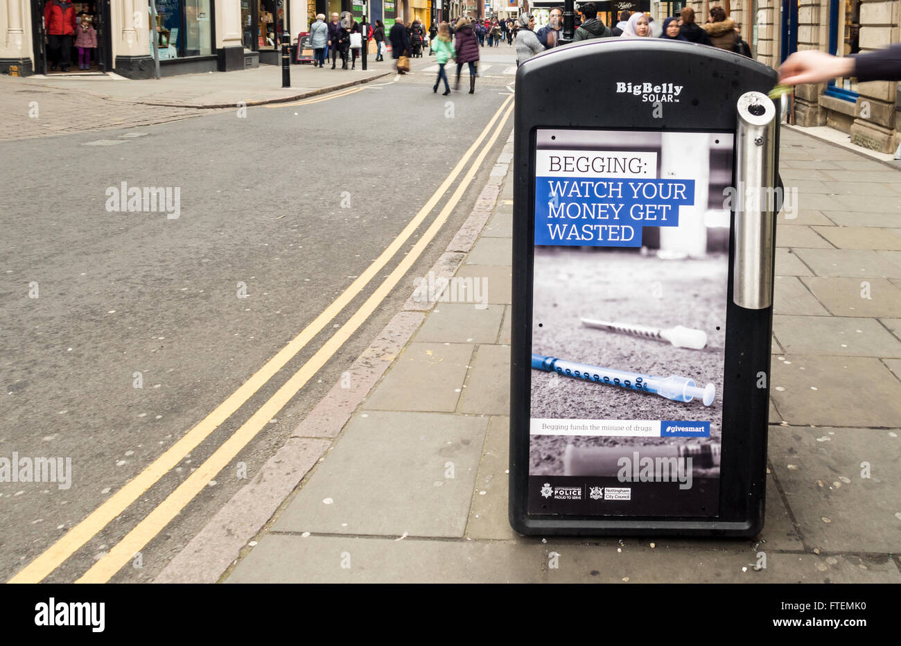 Persona la mano della lettiera operativo bin che è adornata con anti accattonaggio inserzioni da Nottingham City Council (manodopera) Foto Stock