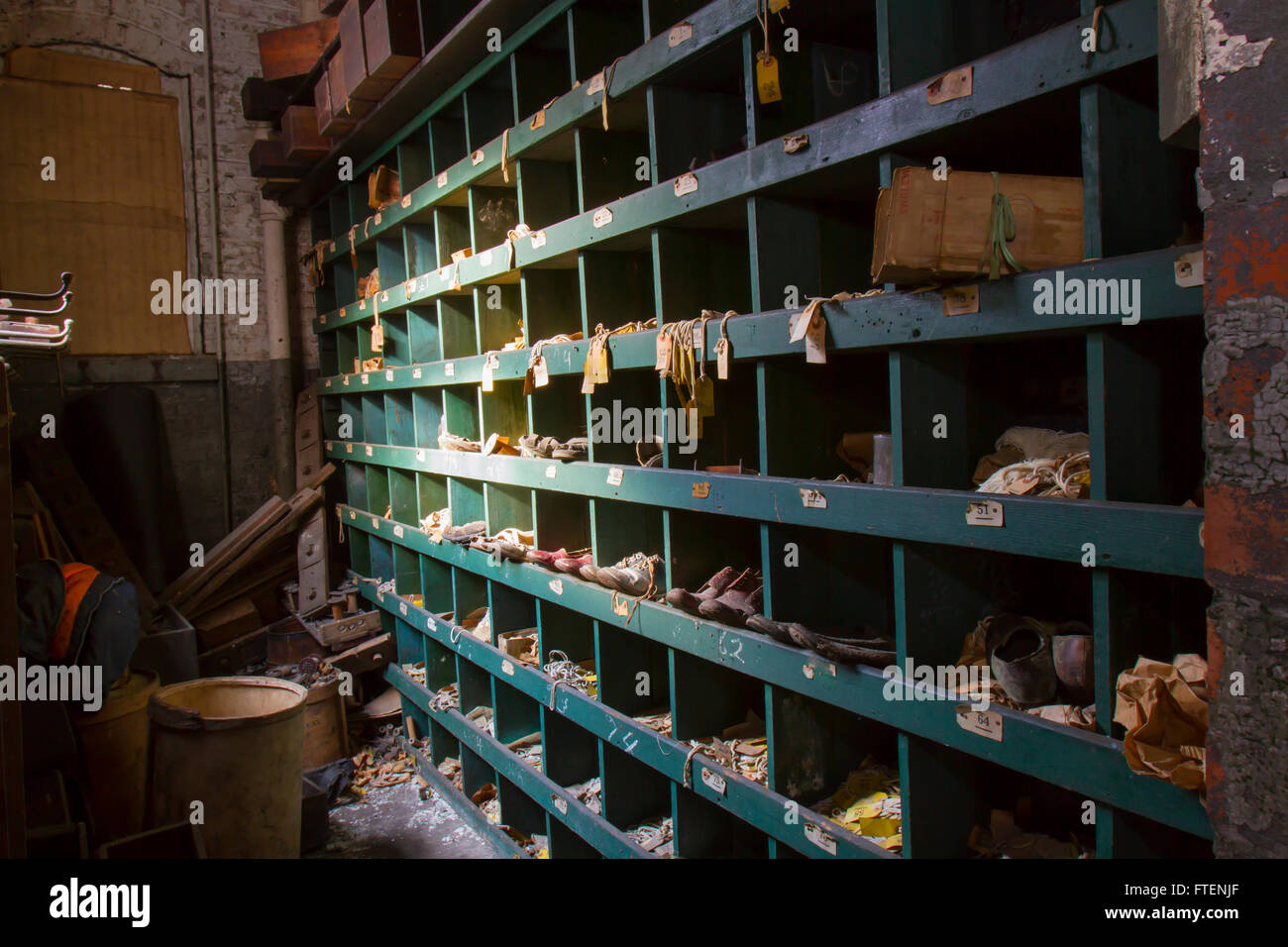 Vano portaoggetti di storage con le scarpe e le etichette nel giro di un secolo la seta gettando fabbrica. Foto Stock