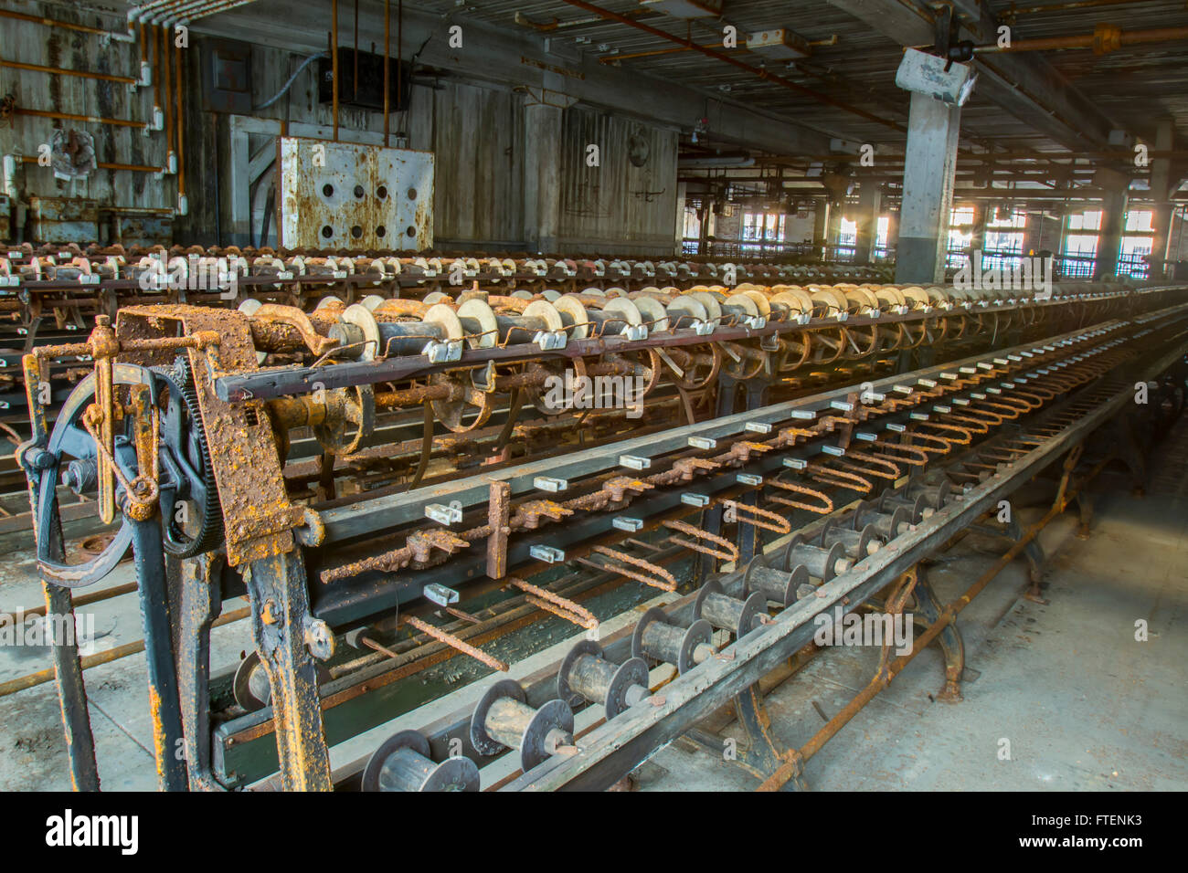 Arrugginimento attrezzatura sulla fabbrica di abbandono di svolta del secolo la seta gettando fabbrica. Foto Stock