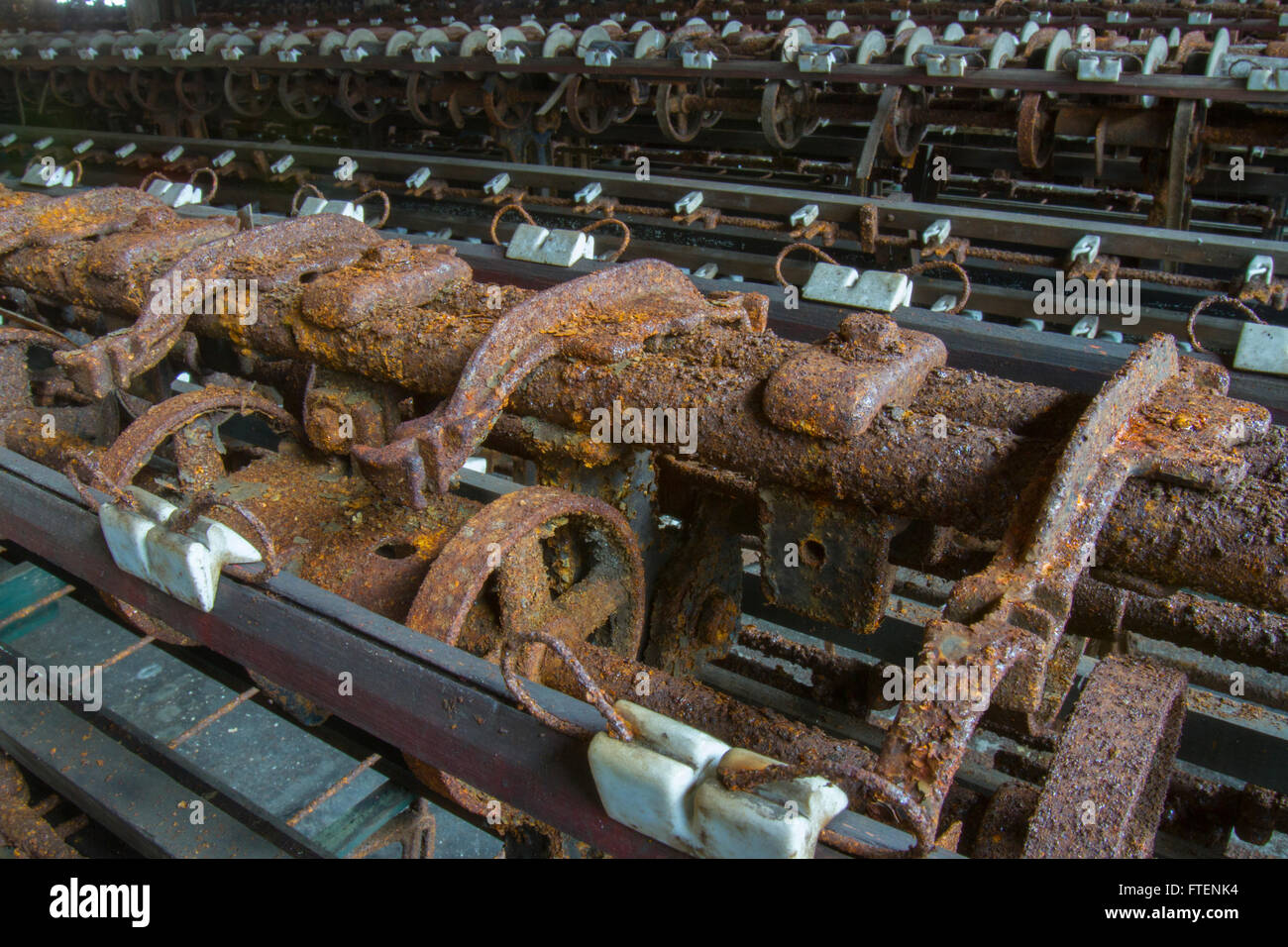 Arrugginimento macchinari abbandonati in giro del secolo la seta gettando fabbrica. Foto Stock