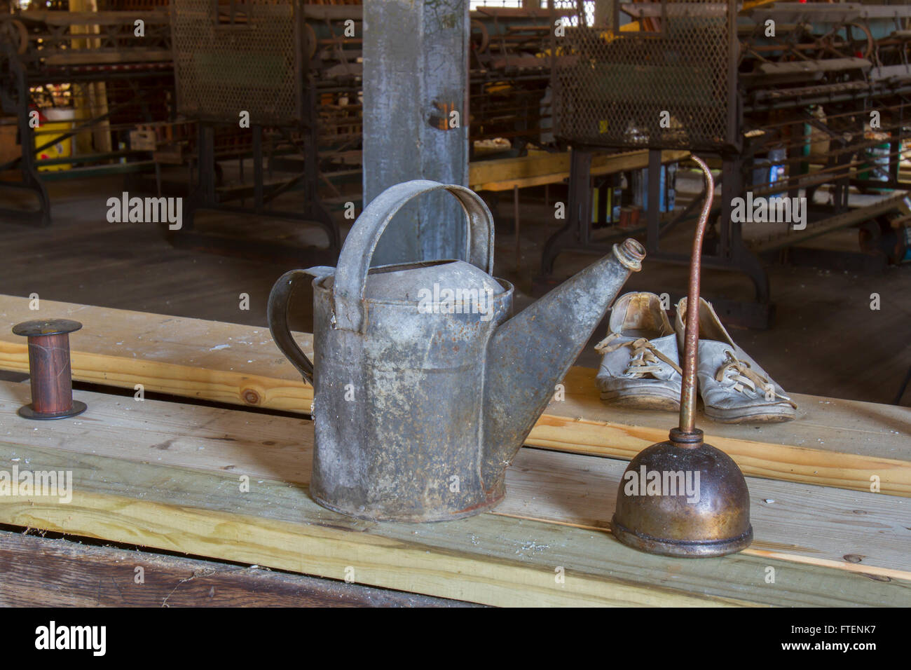 Olio e taniche per l acqua sulla panca di legno a sua volta del secolo la seta gettando fabbrica. Foto Stock