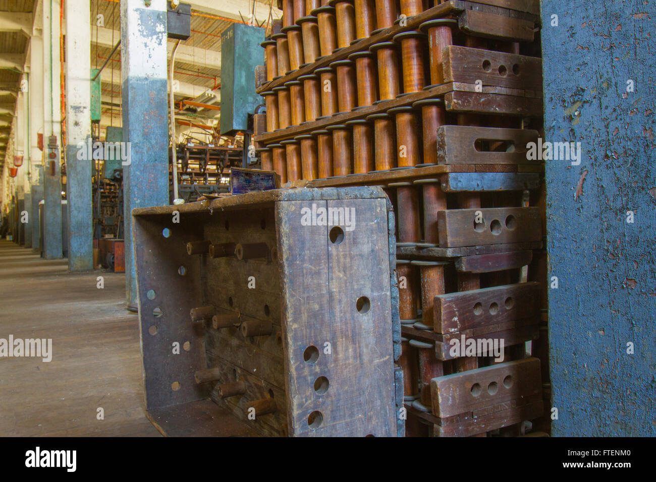 Rack di bobine di legno sul pavimento della fine del secolo la seta gettando fabbrica. Foto Stock