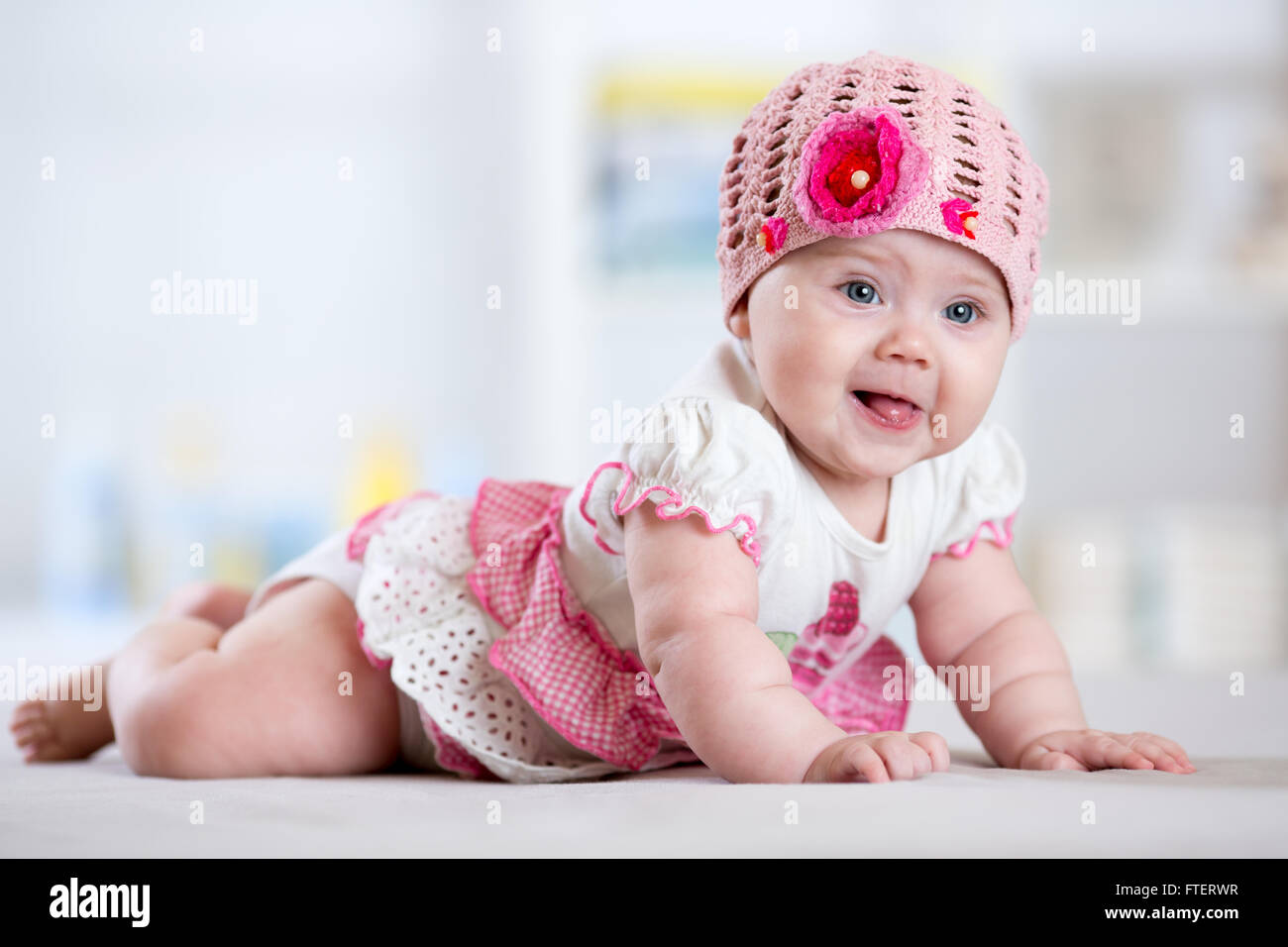 Incantevole bambino bambina con hat giacente sul suo stomaco Foto Stock