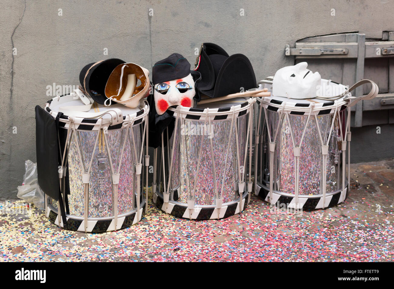 Tre tamburi sul lato della strada con le maschere sulla parte superiore in attesa per i loro proprietari durante il Carnevale di Basilea 2016 Foto Stock